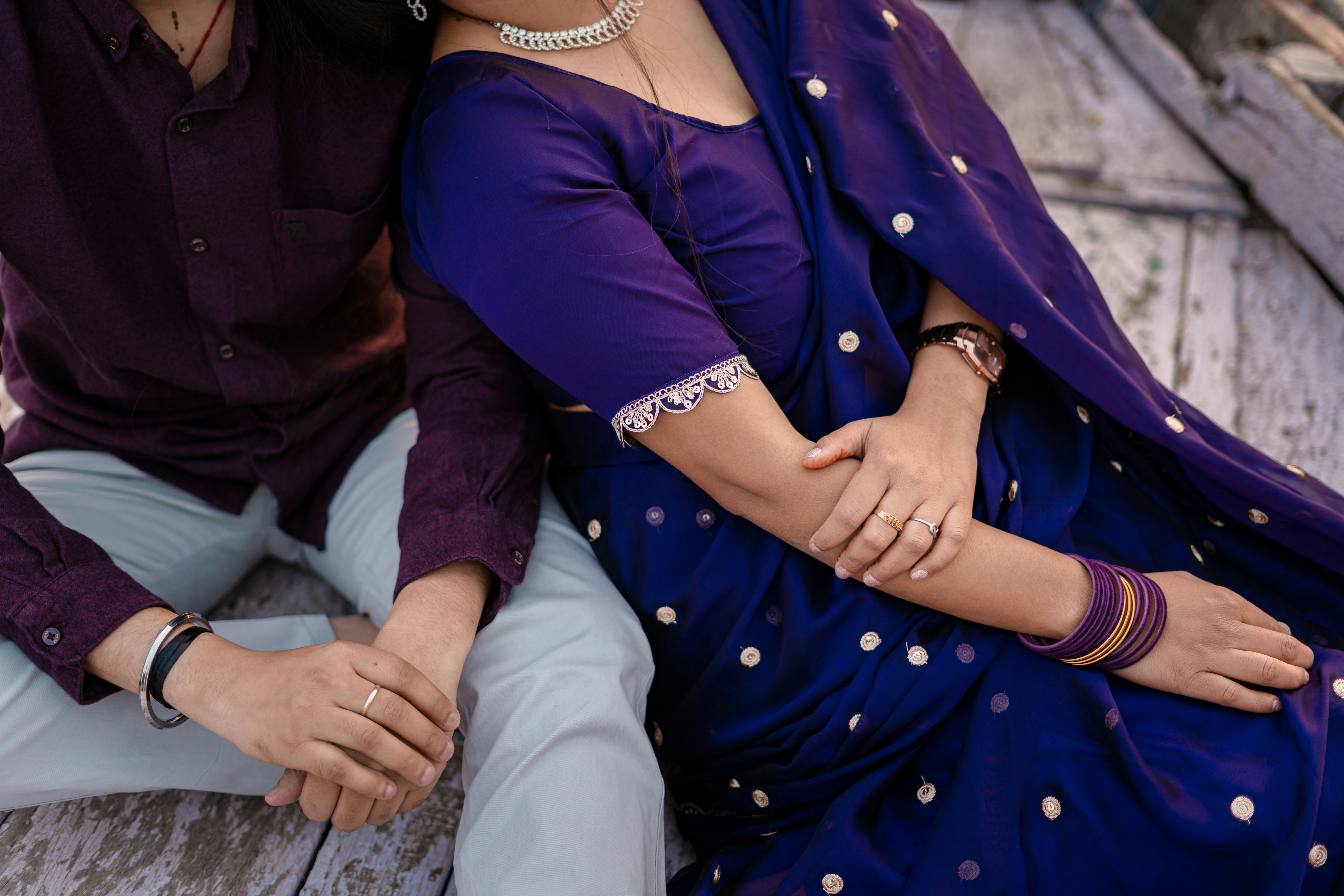 Paar, das Händchen hält und traditionelle indische Kleidung trägt.