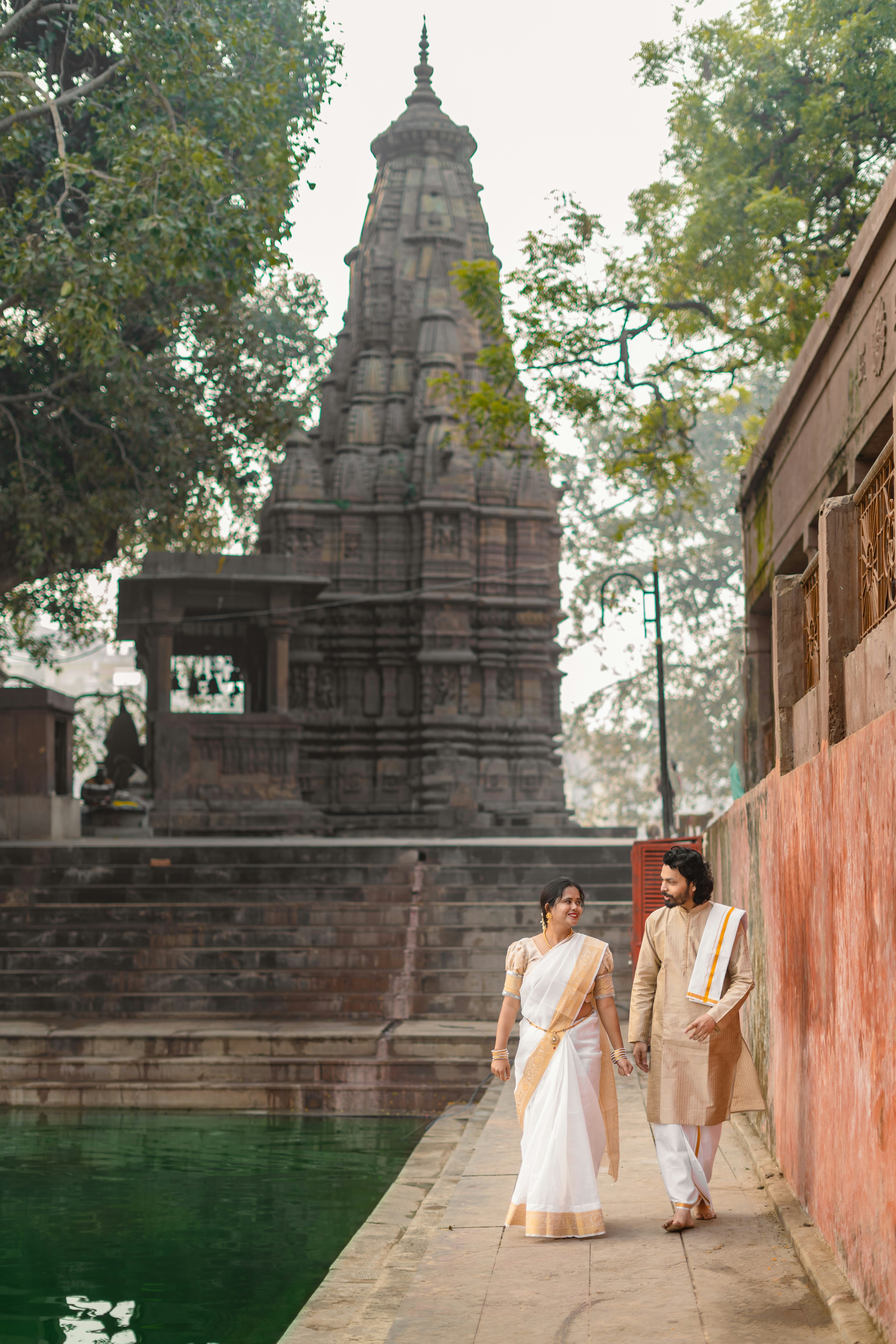 Paar, das an einem Tempel mit Teich vorbeigeht, spazieren