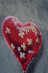 A red heart with many bandages on it