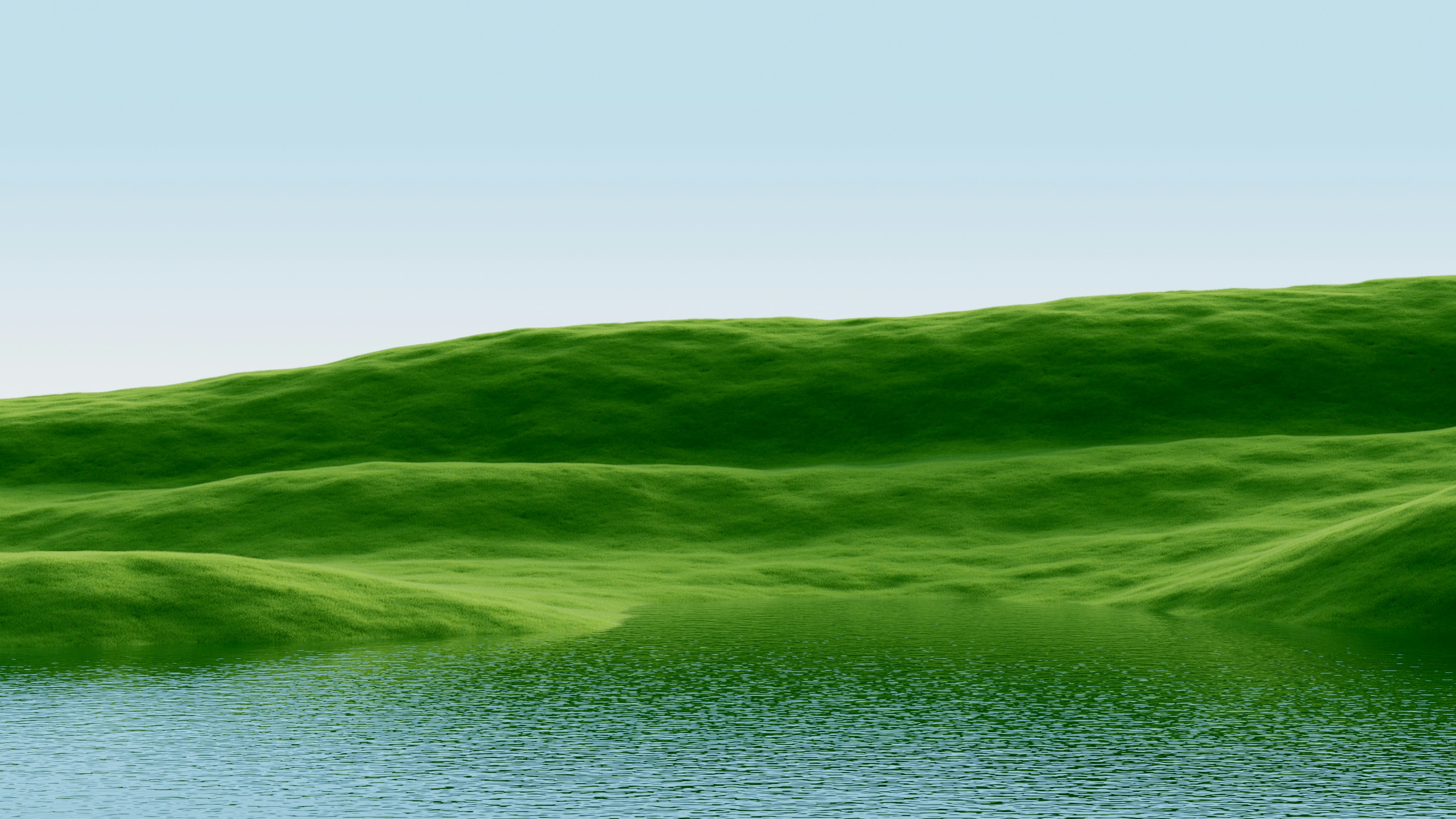 Green rolling hills meet a calm blue body of water.