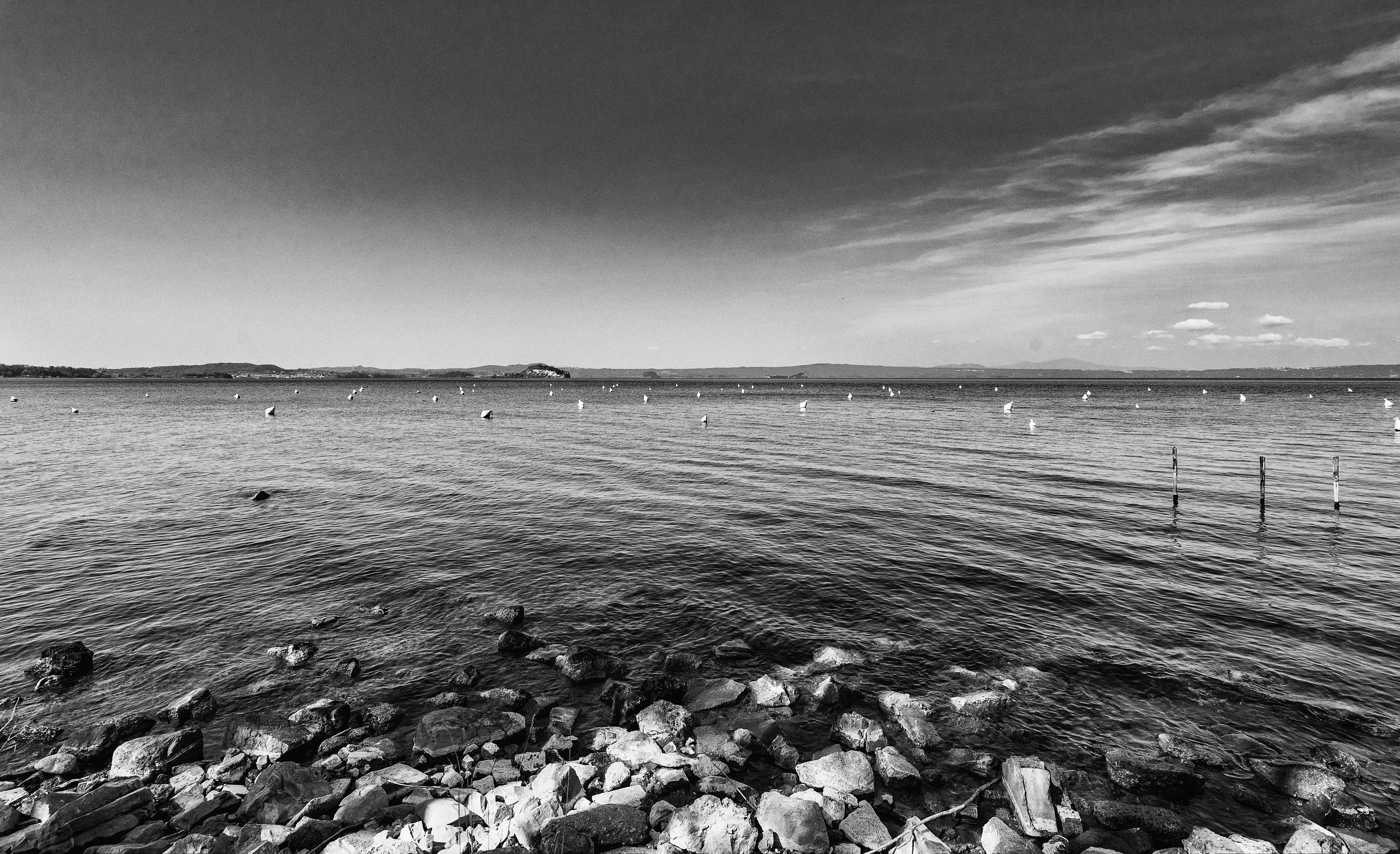 Rocky shore of a large lake with buoys