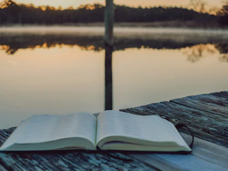 Open book on a wooden dock by the water
