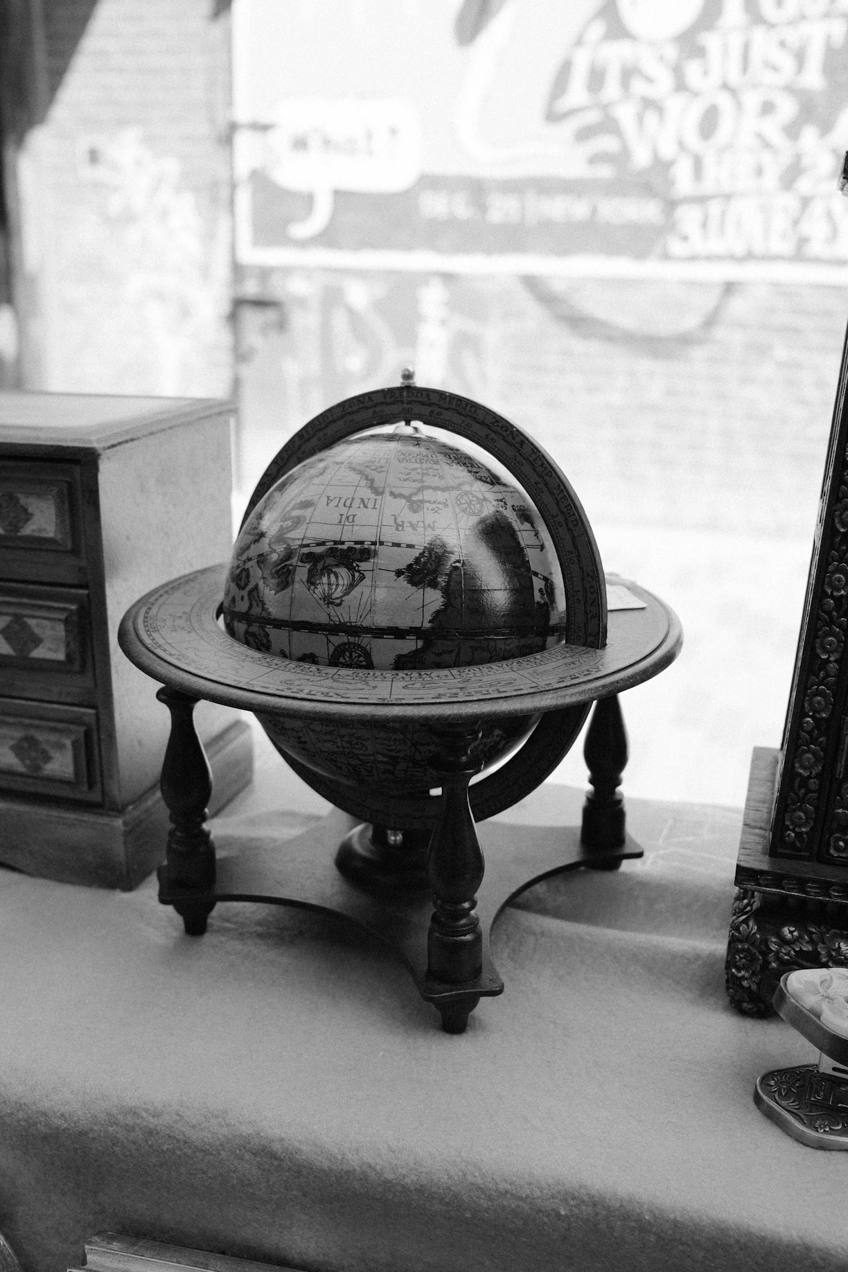 An antique globe on a wooden stand.