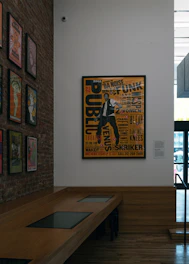 Poster of a man with text on a brick wall.