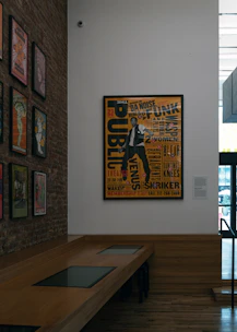 Poster of a man with text on a brick wall.