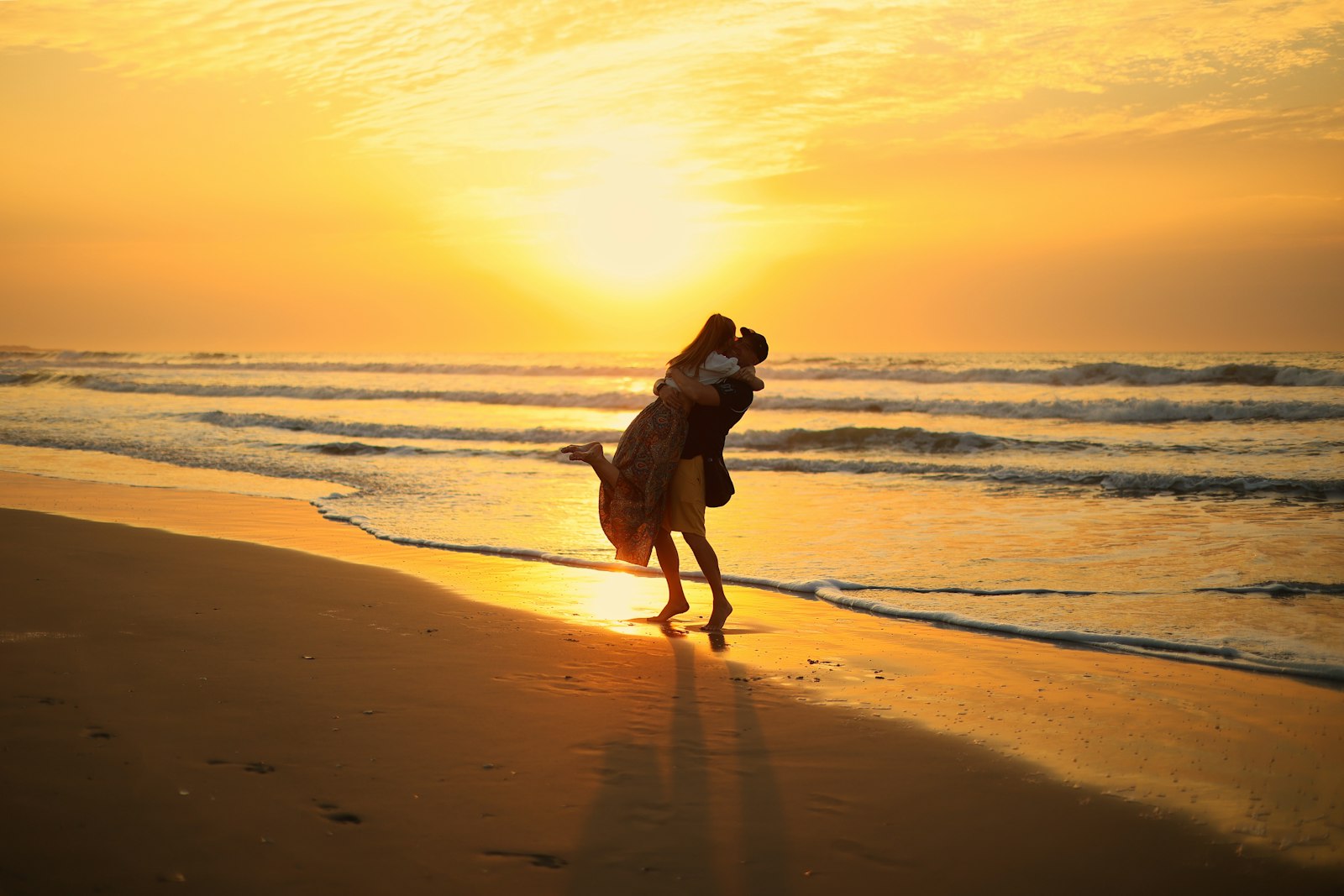Couple embracing on tropical beach at golden hour