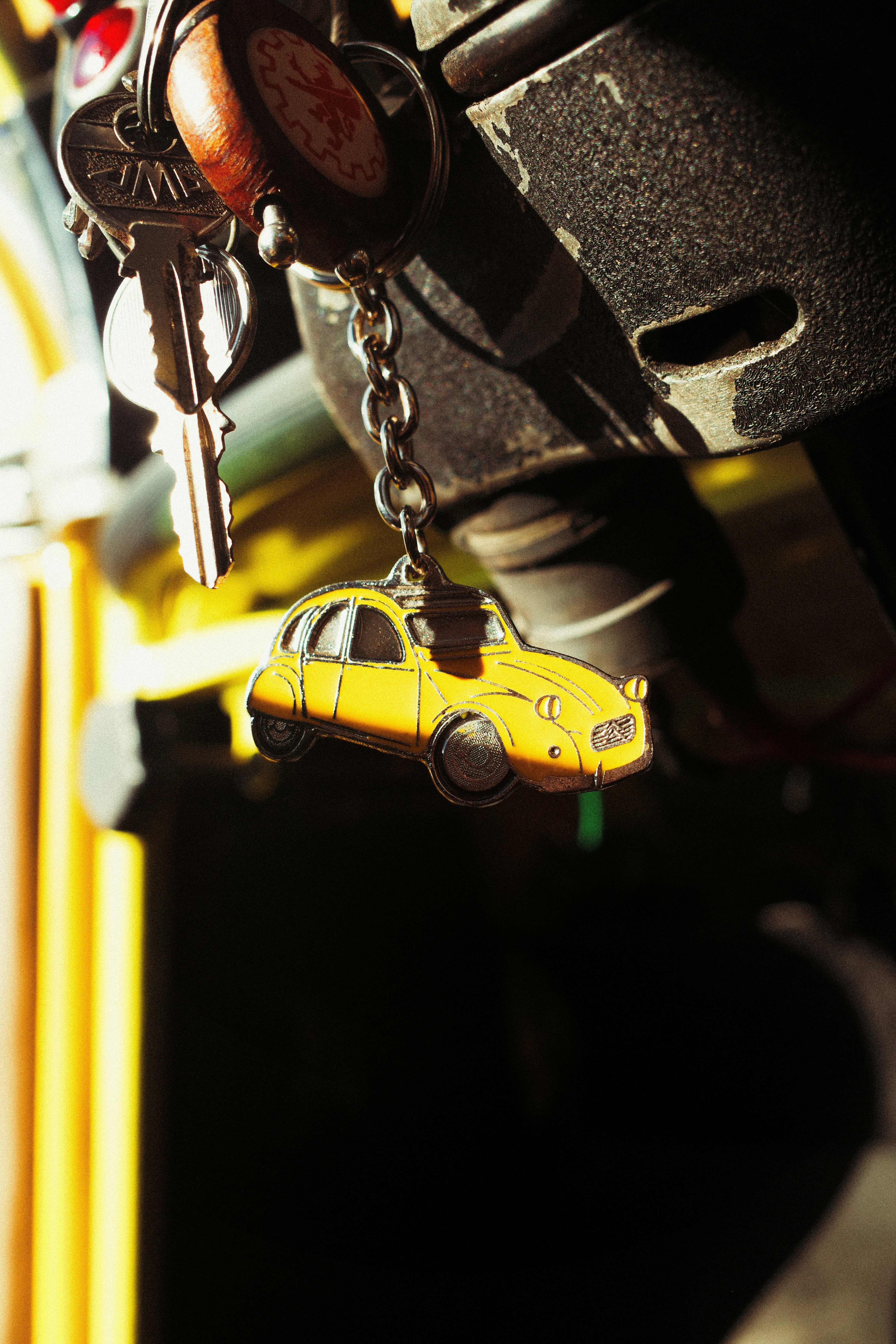 Gantungan kunci mobil kuning tergantung dari kunci.