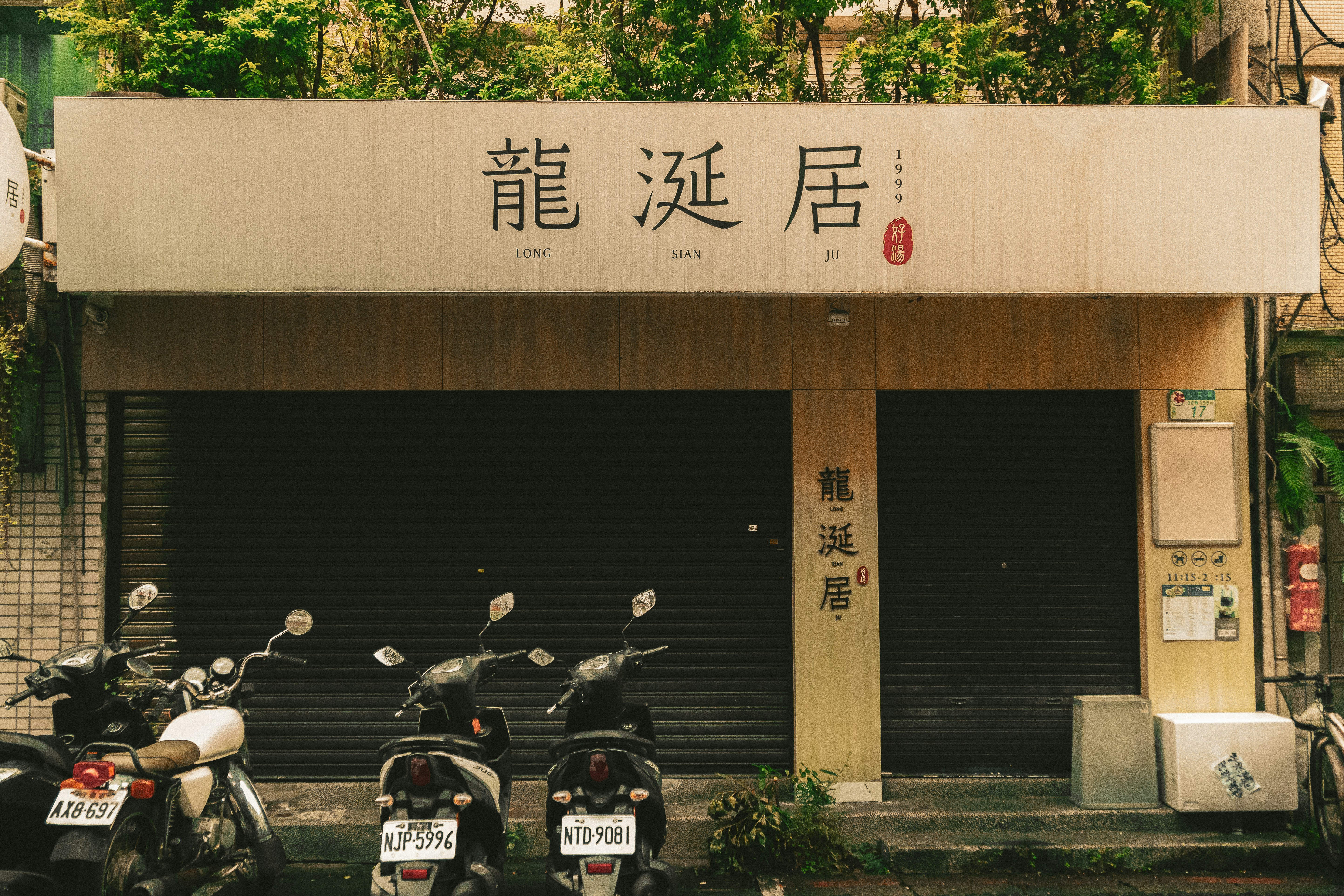 Gebäude mit chinesischen Schriftzeichen und geparkten Rollern