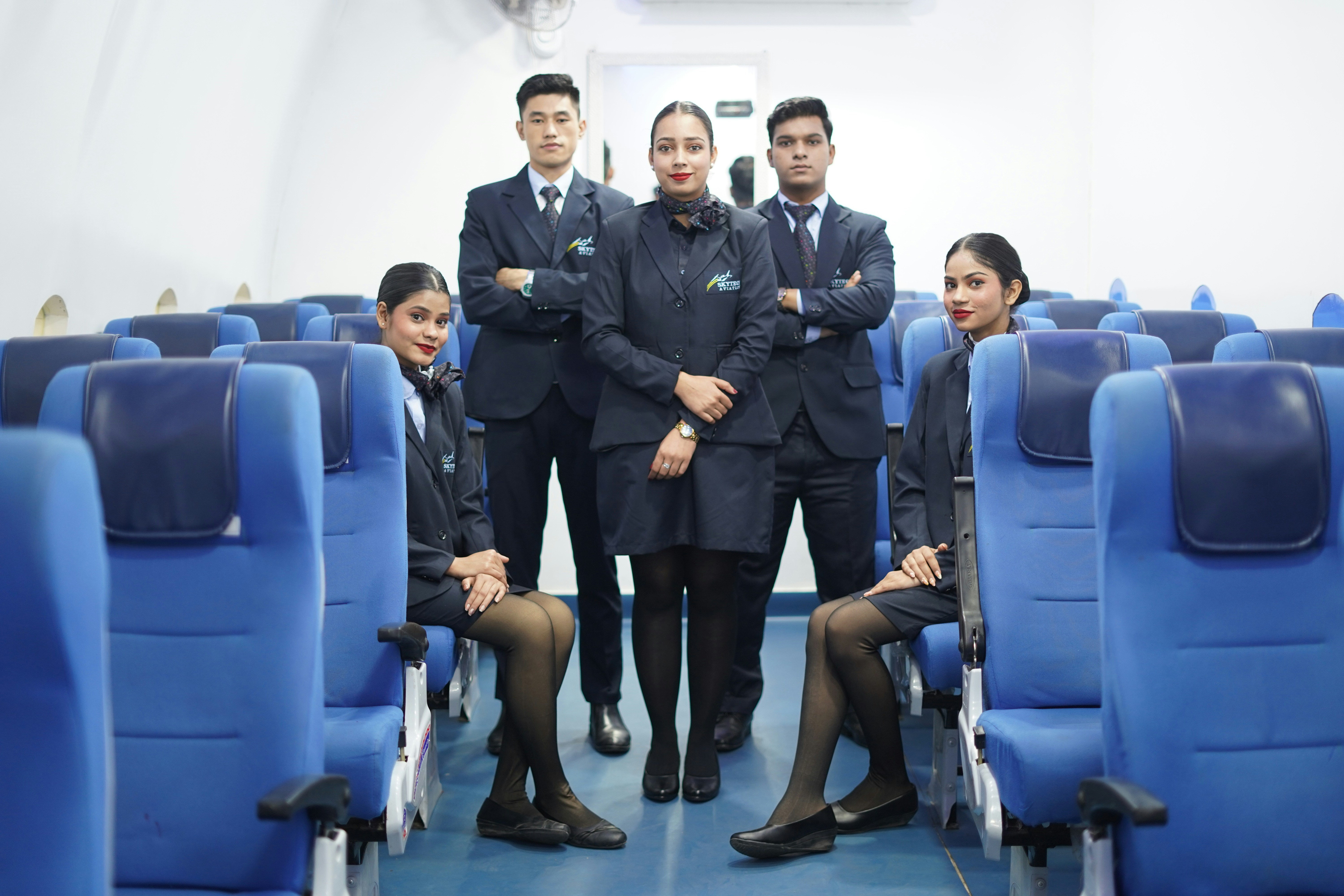 Flight attendants posing in airplane cabin