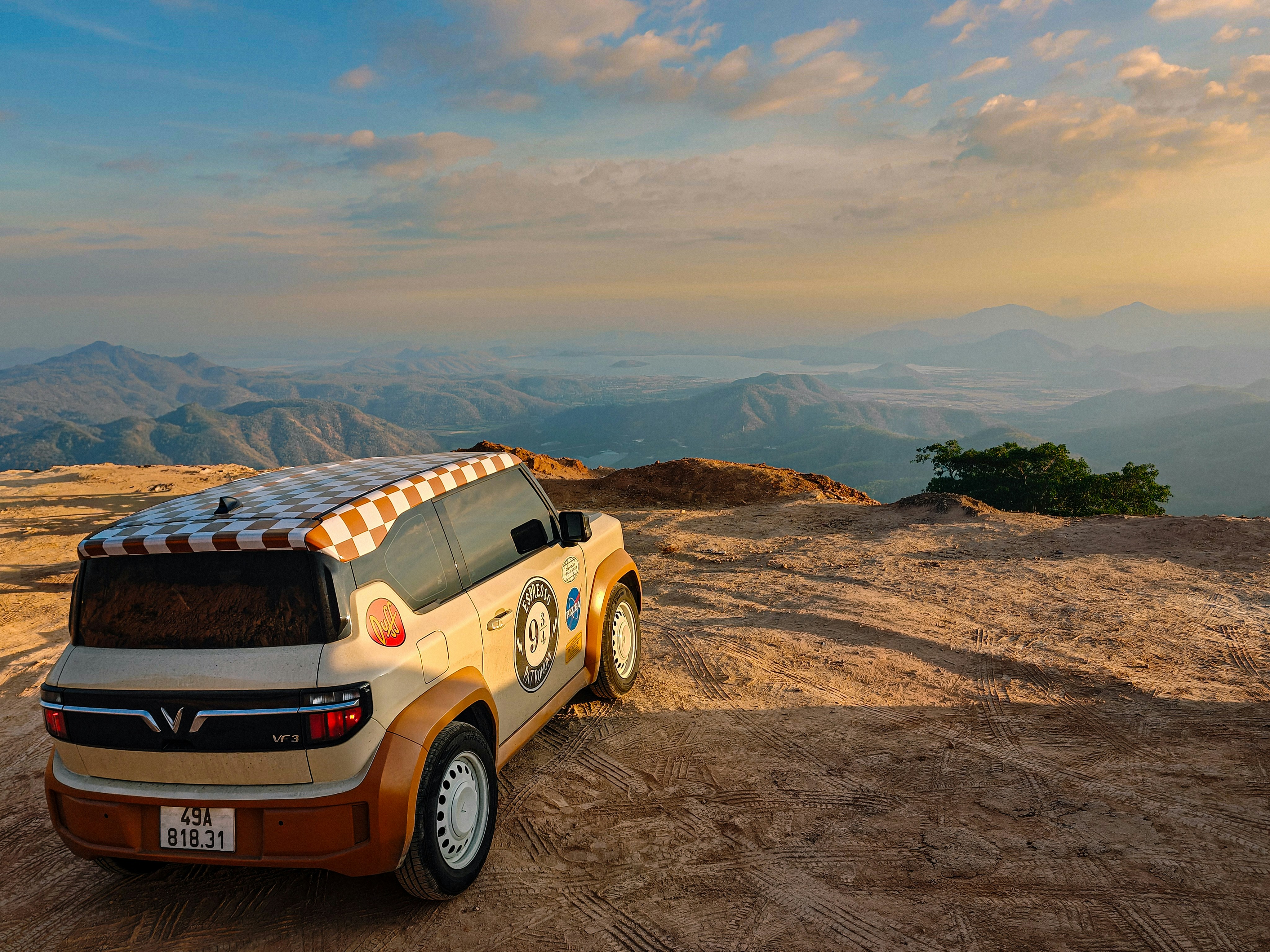 Ein einzigartiges Fahrzeug, das bei Sonnenuntergang auf einem felsigen Aussichtspunkt geparkt ist.
