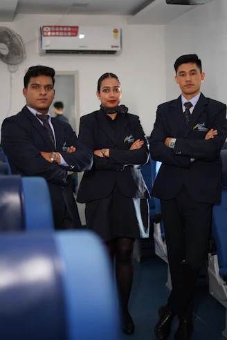 Three flight attendants in uniform with arms crossed
