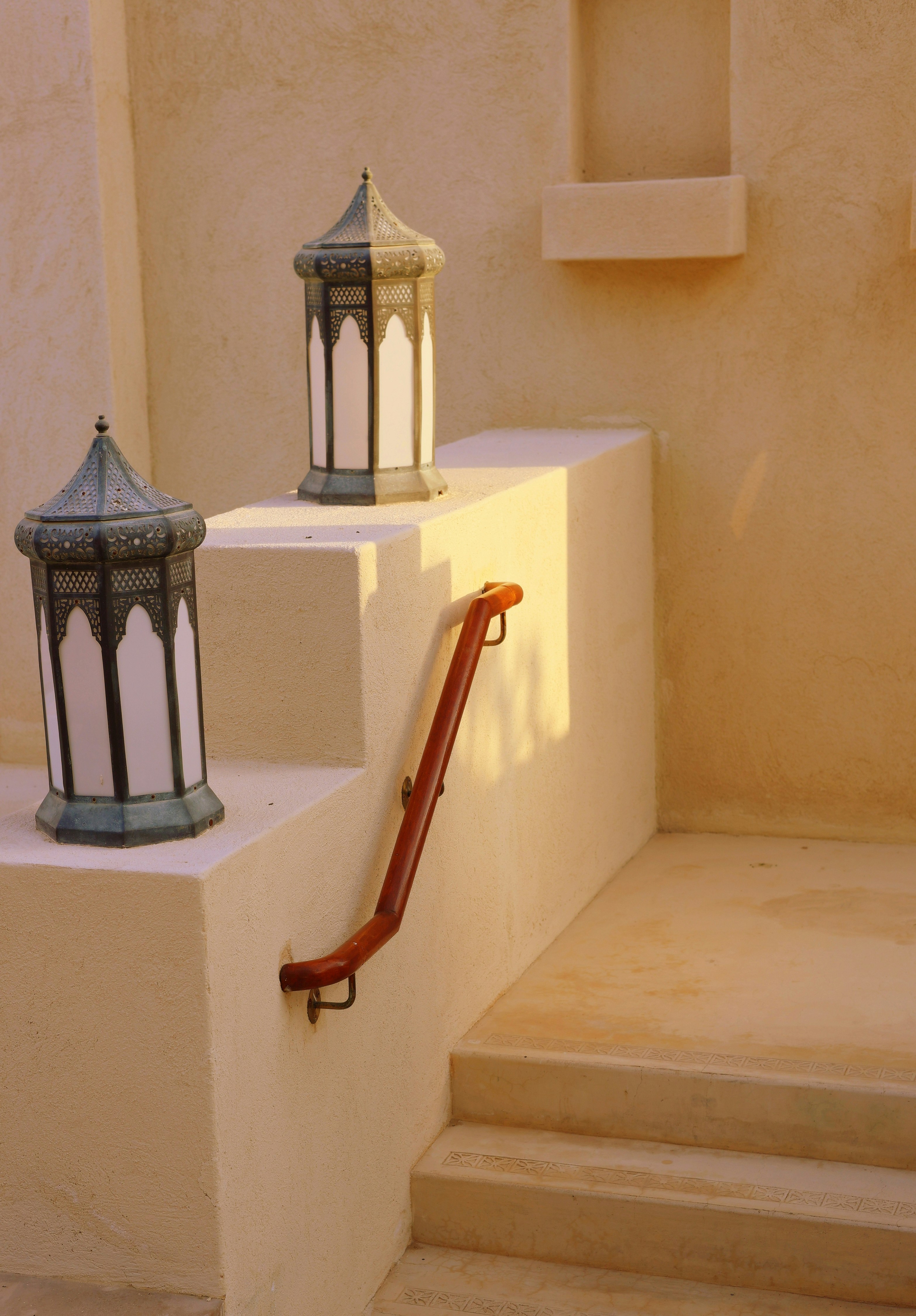 Two ornate lanterns on a staircase landing.