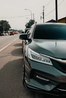 Dark colored sedan parked on the side of the road.