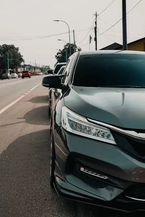 Dark colored sedan parked on the side of the road.