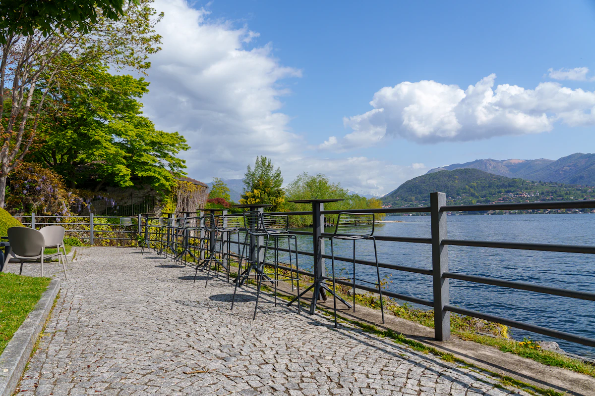 Chemin longeant un lac calme, montagnes au loin
