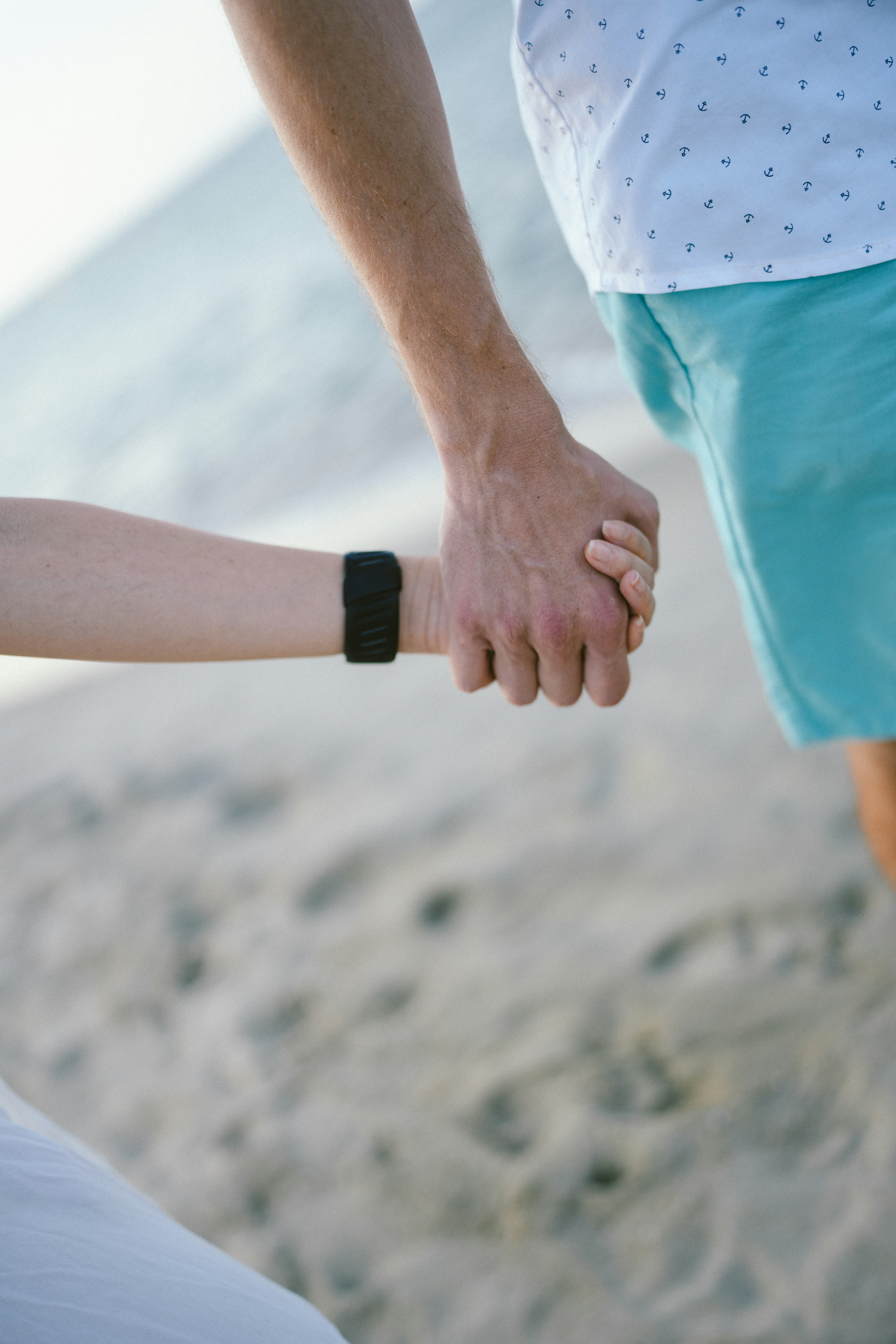 砂浜で手をつないだカップル