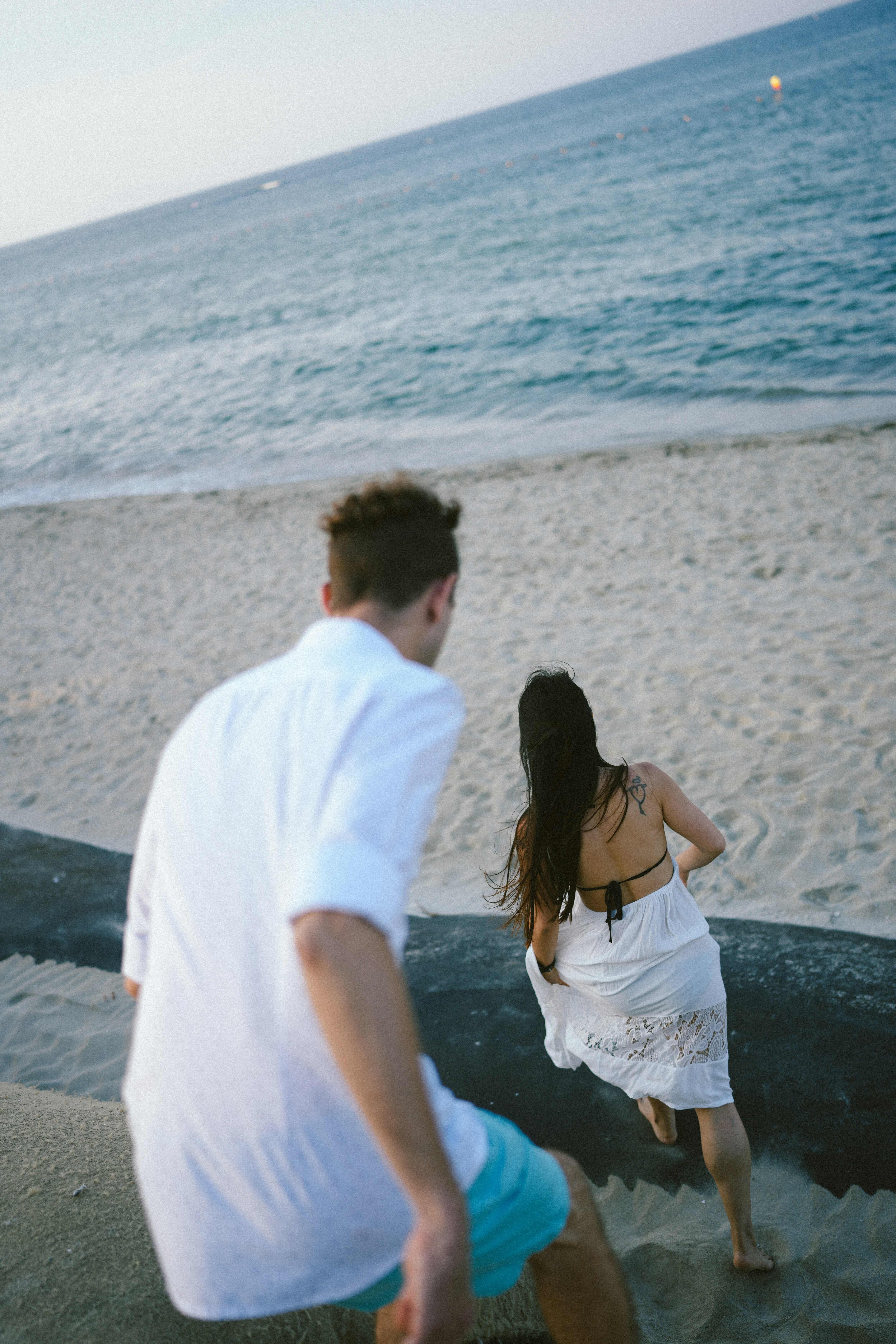 海の近くの砂浜を歩くカップル