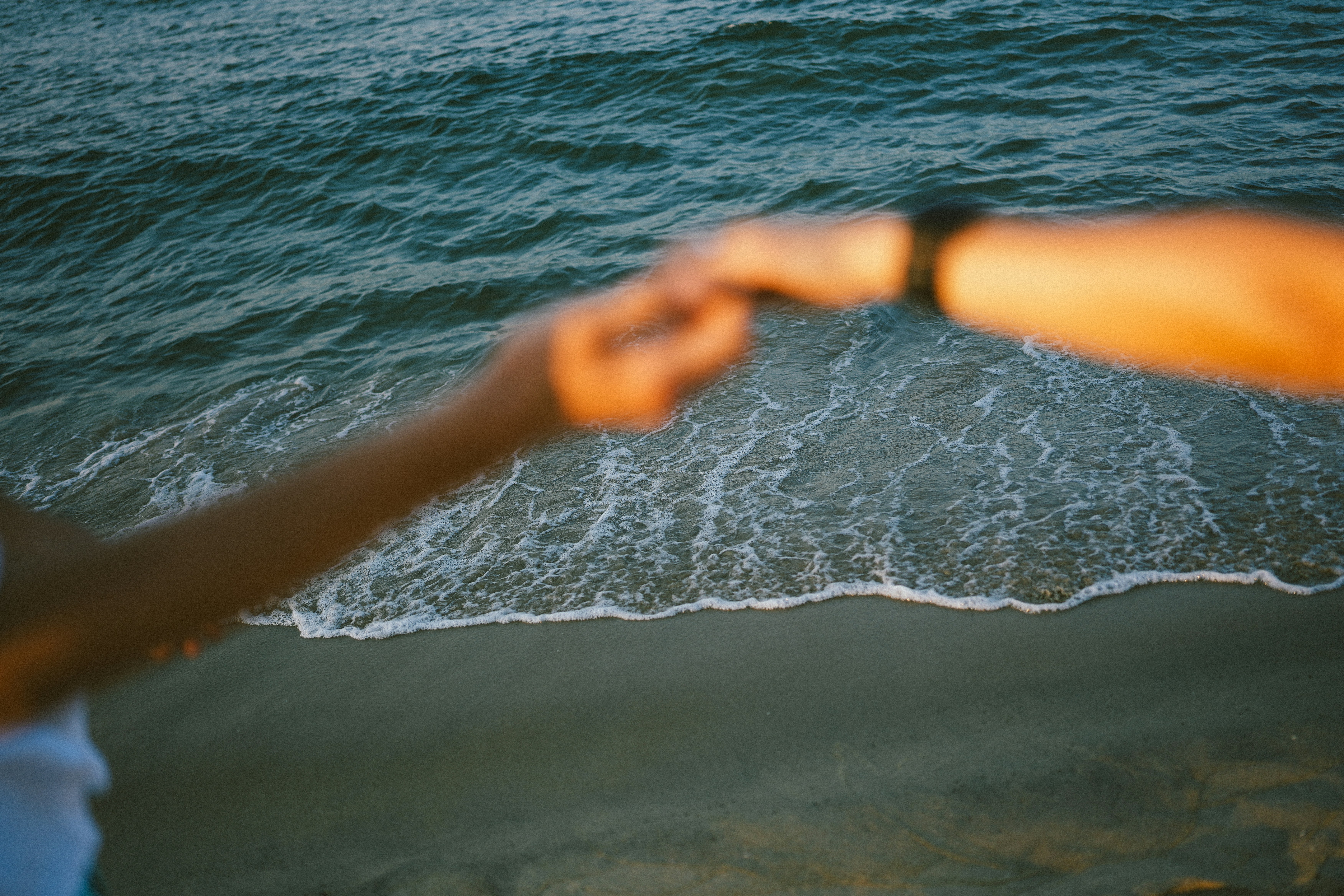 海の波を越えて伸びる二つの手