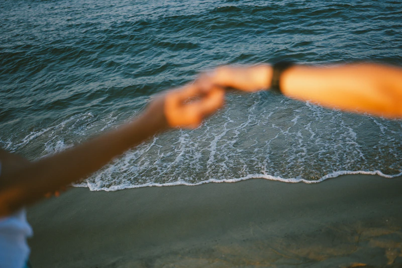 Hände eines Sugar Paares über Meereswellen