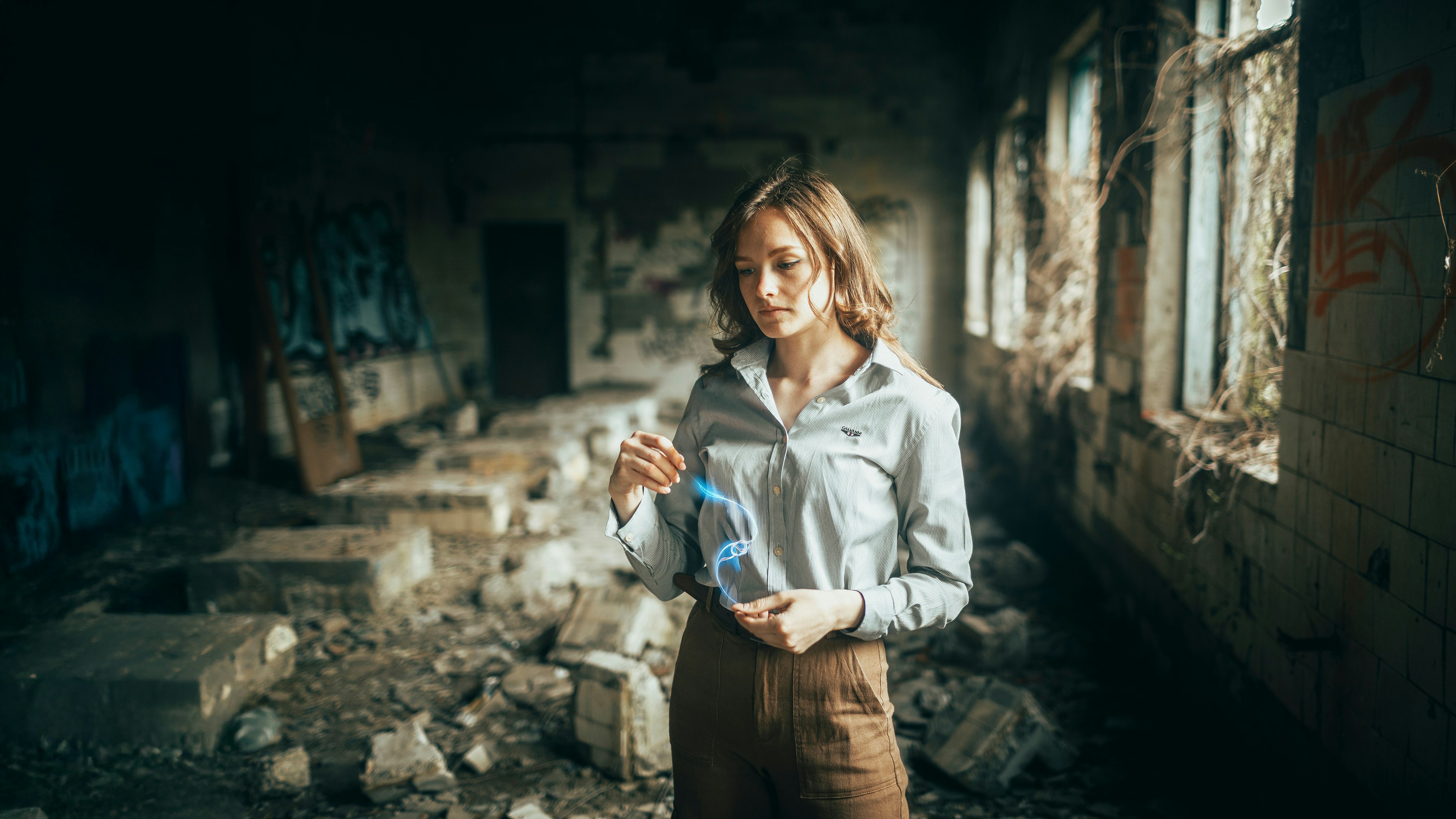 Young woman in a ruined building holding a blue object