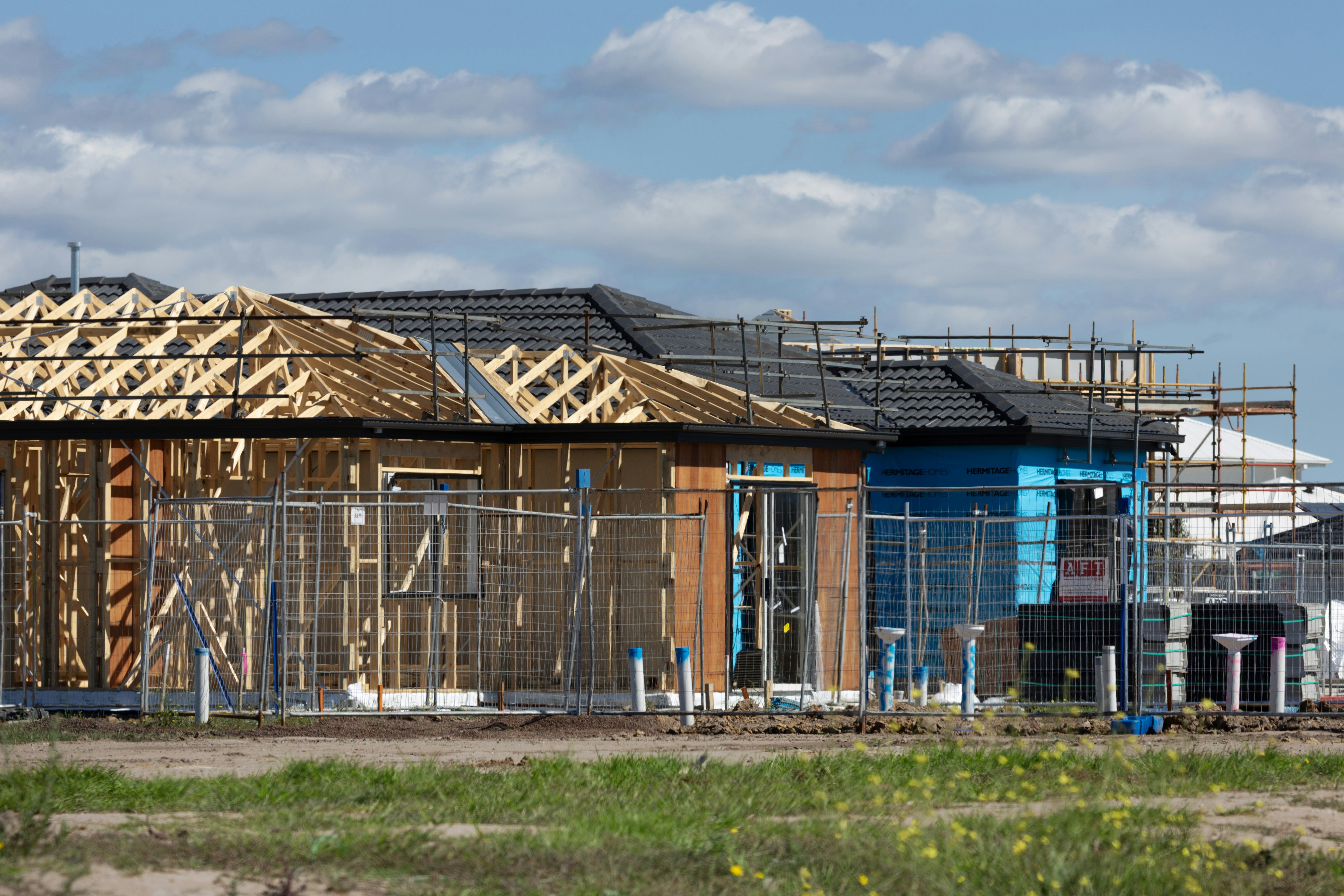 Several houses under construction with wooden frames.