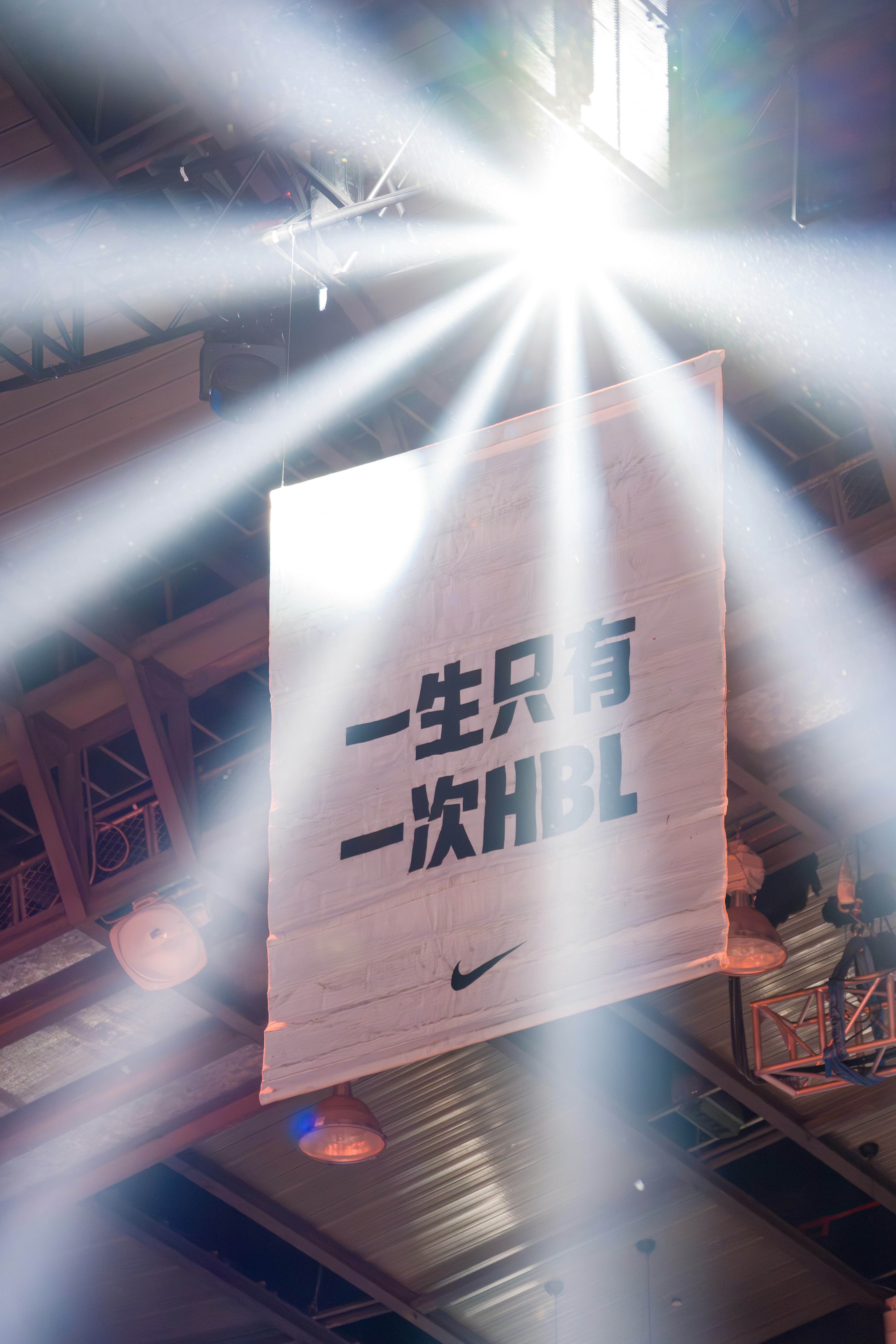 Banner mit chinesischem Text und Nike-Logo unter Scheinwerfern