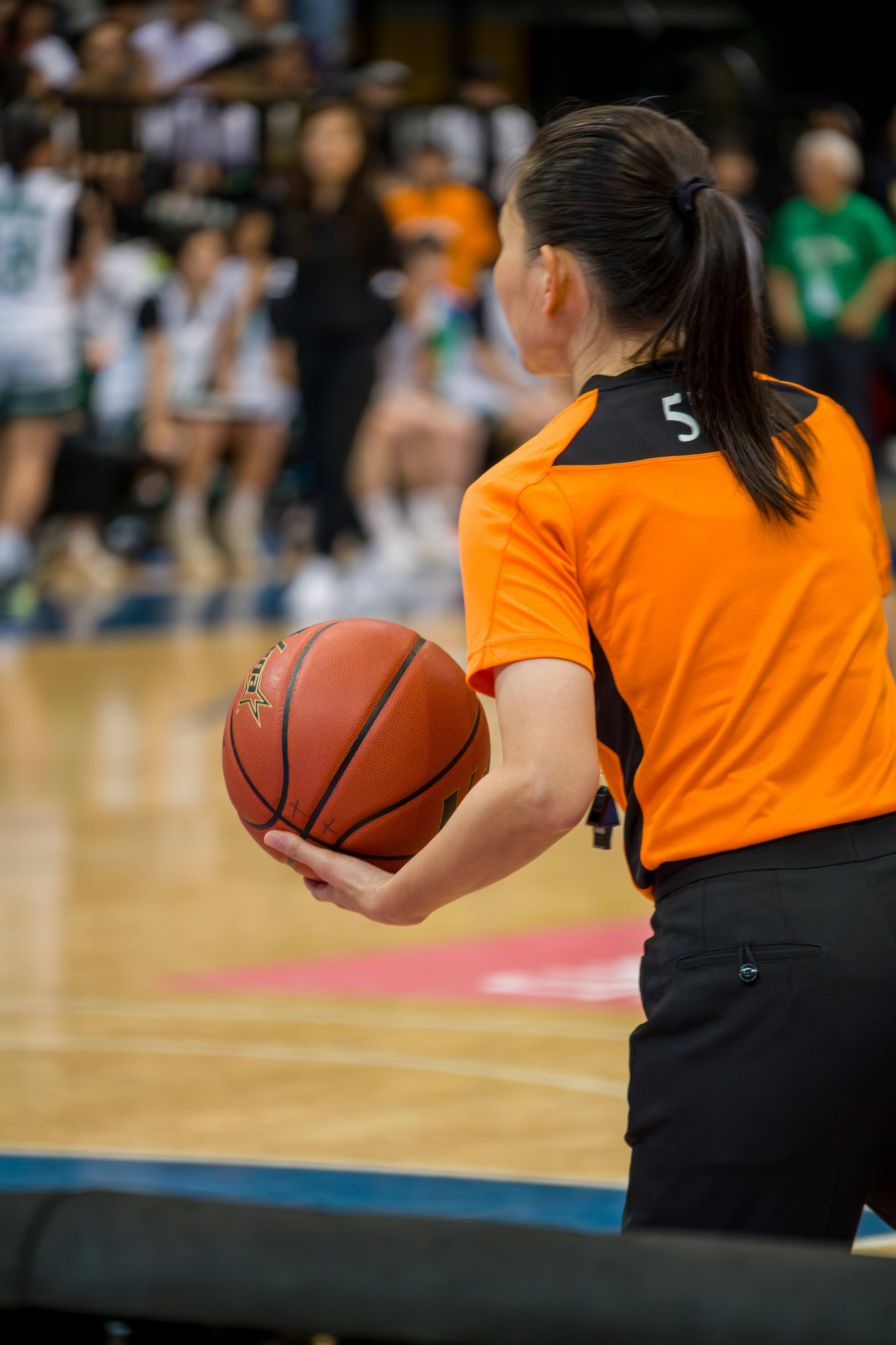 Árbitro de basquete segurando a bola em quadra