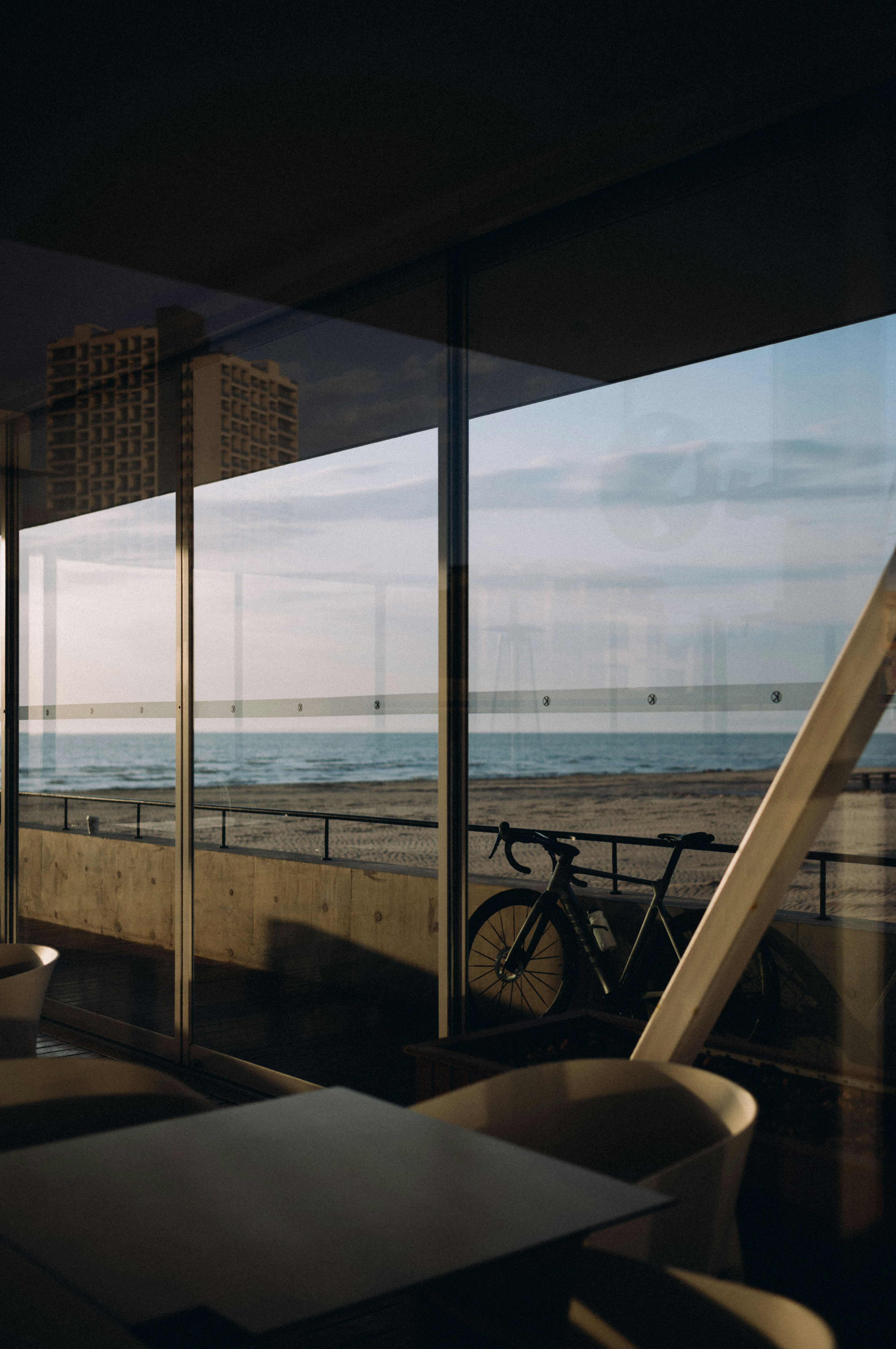 A bicycle parked on a beach promenade by the ocean.