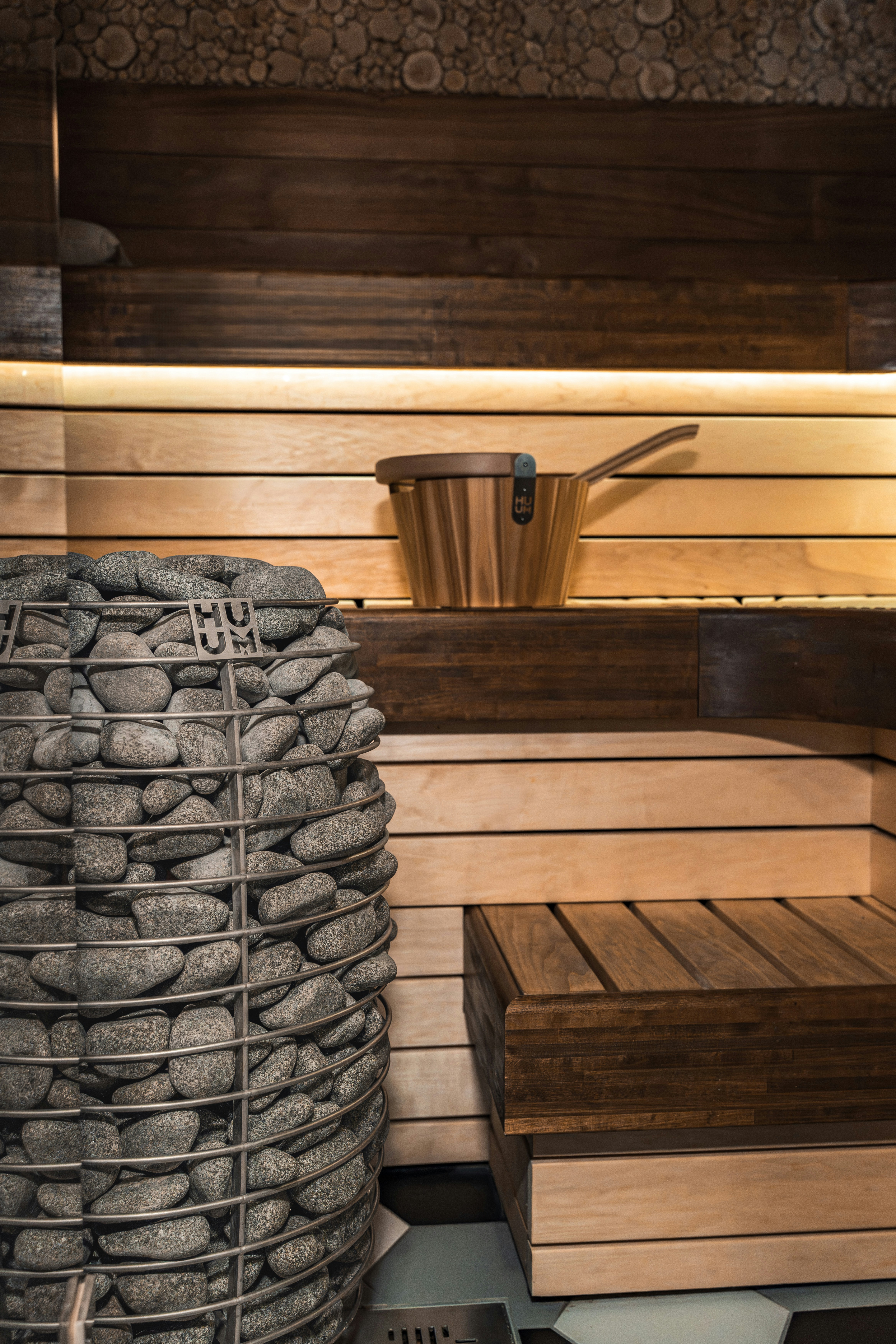 Interior sauna tradisional dengan bangku kayu dan batu.