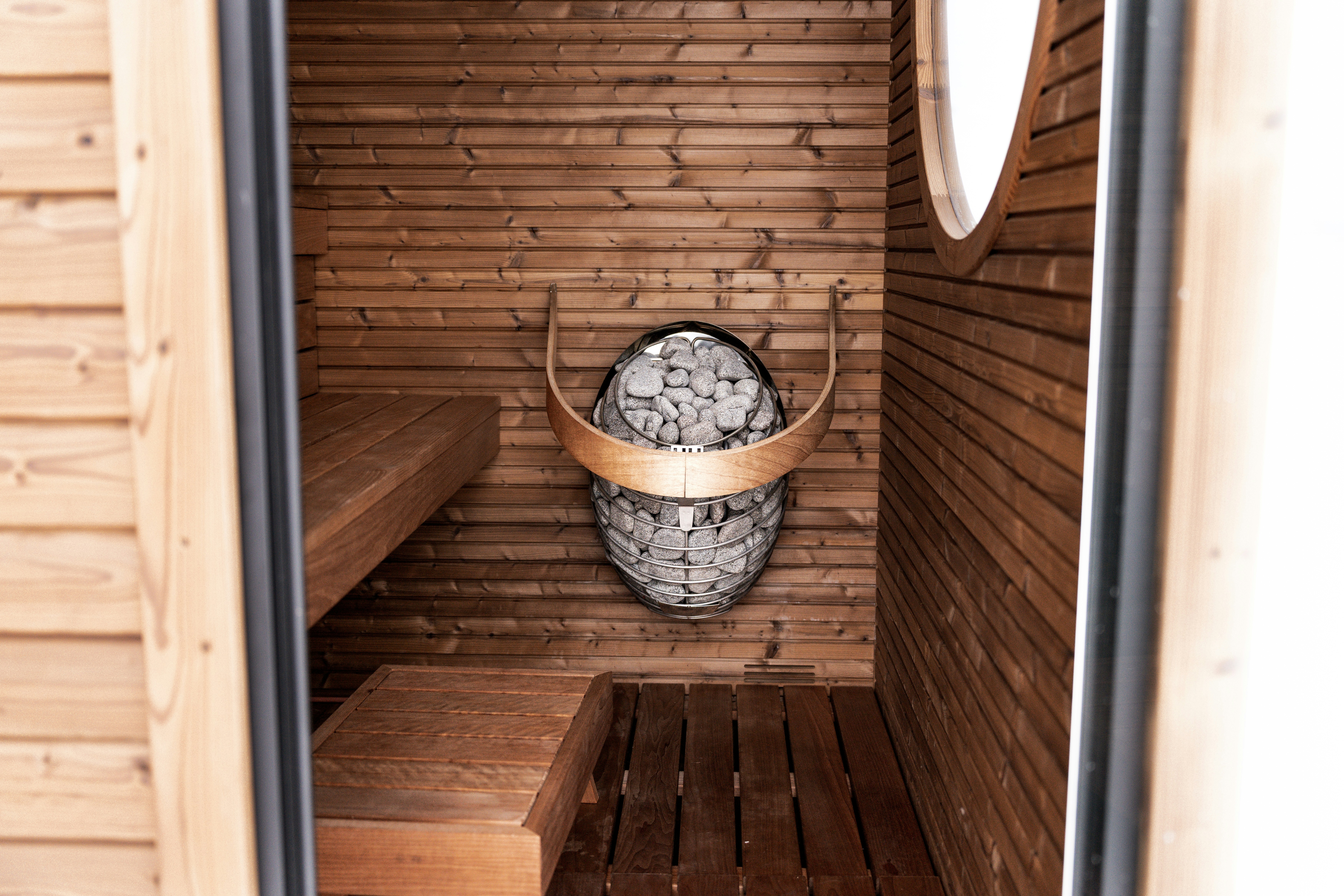 Interior sauna kayu dengan pemanas batu dan bangku