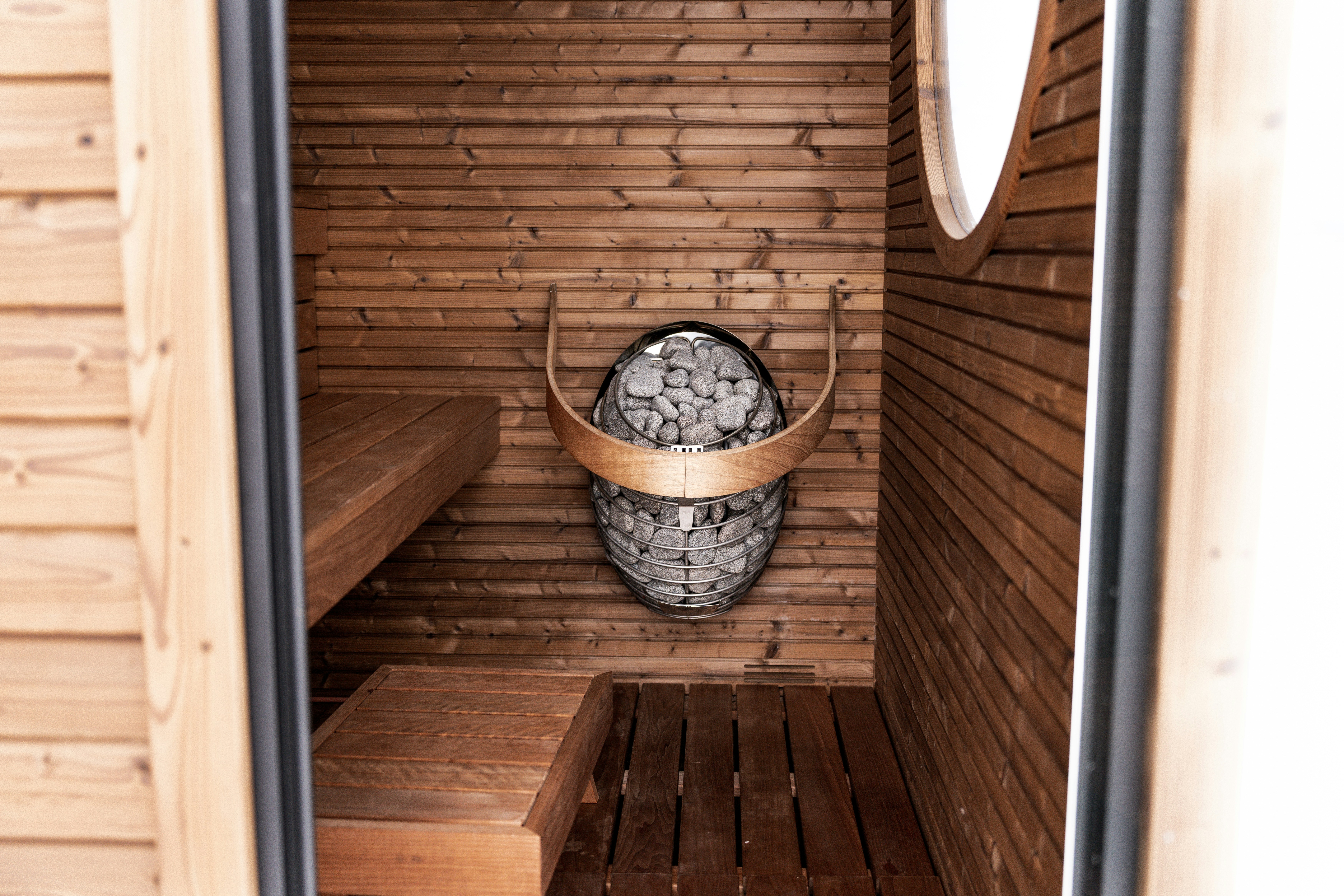 Interior sauna kayu dengan pemanas batu.