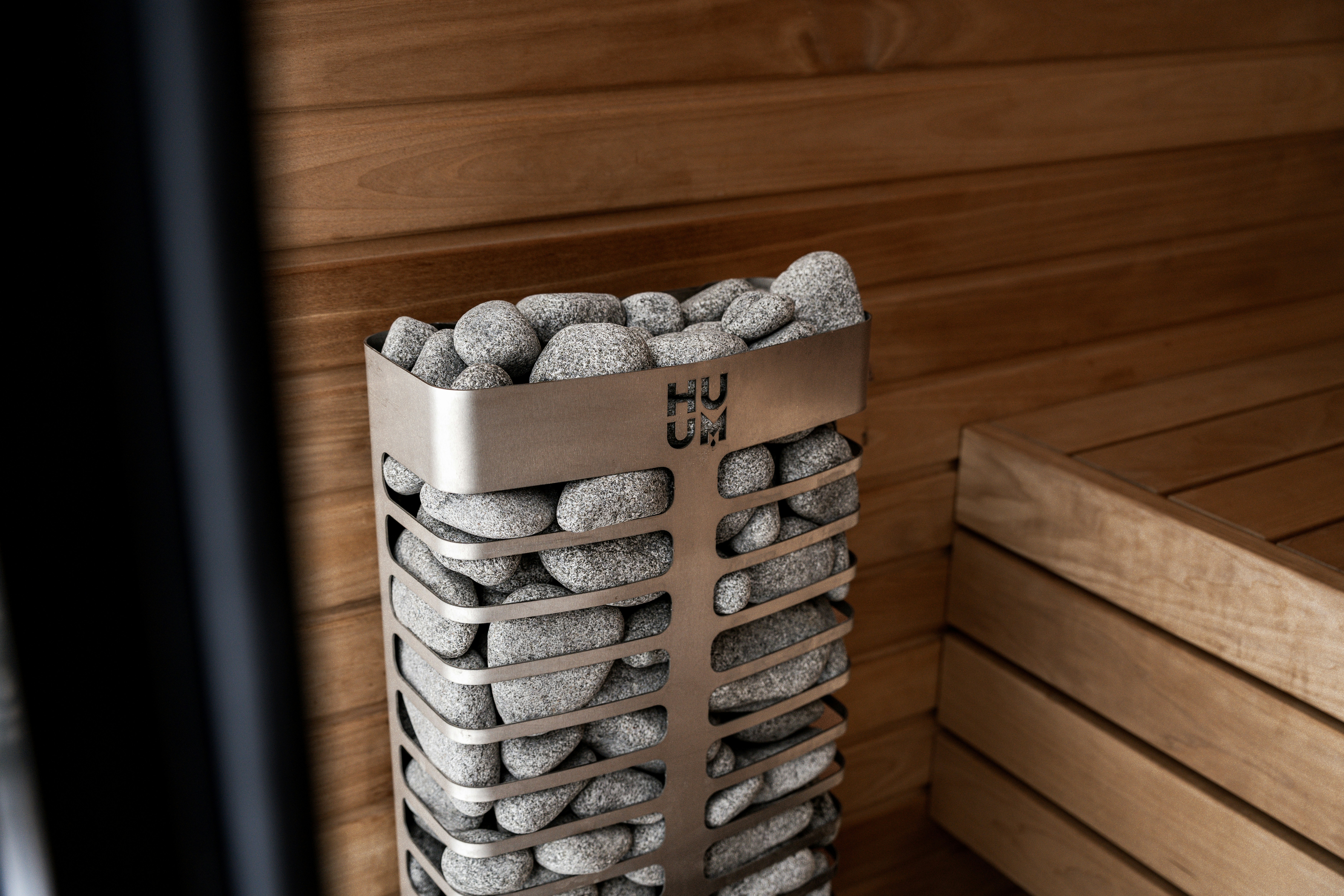 Pemanas sauna diisi dengan batu dan bangku kayu.