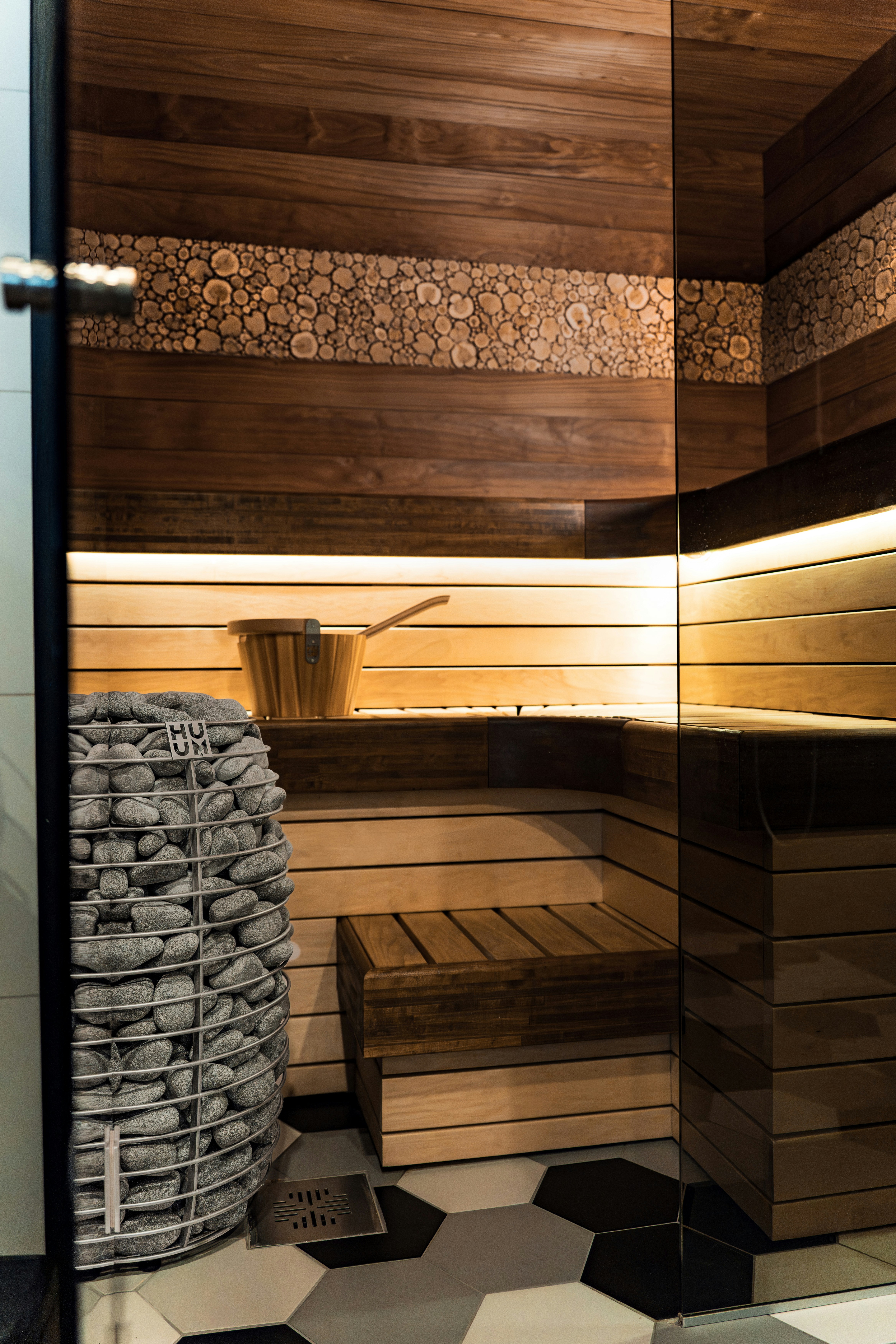 Interior sauna kayu modern dengan batu dan ember