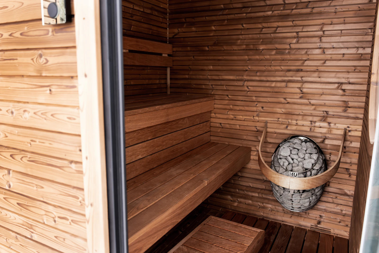 Traditional wooden sauna interior with benches and stone heater