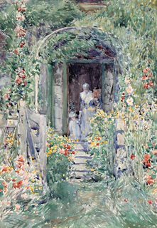 Two women and a child in a garden archway