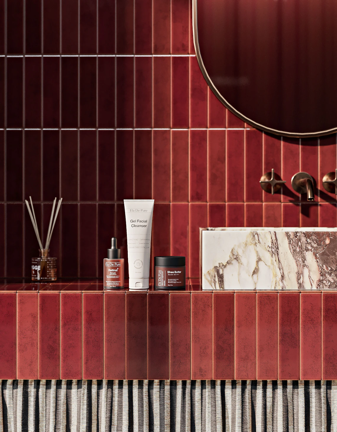 Premium facial cleanser, serum, and moisturizer arranged on a refined bathroom counter