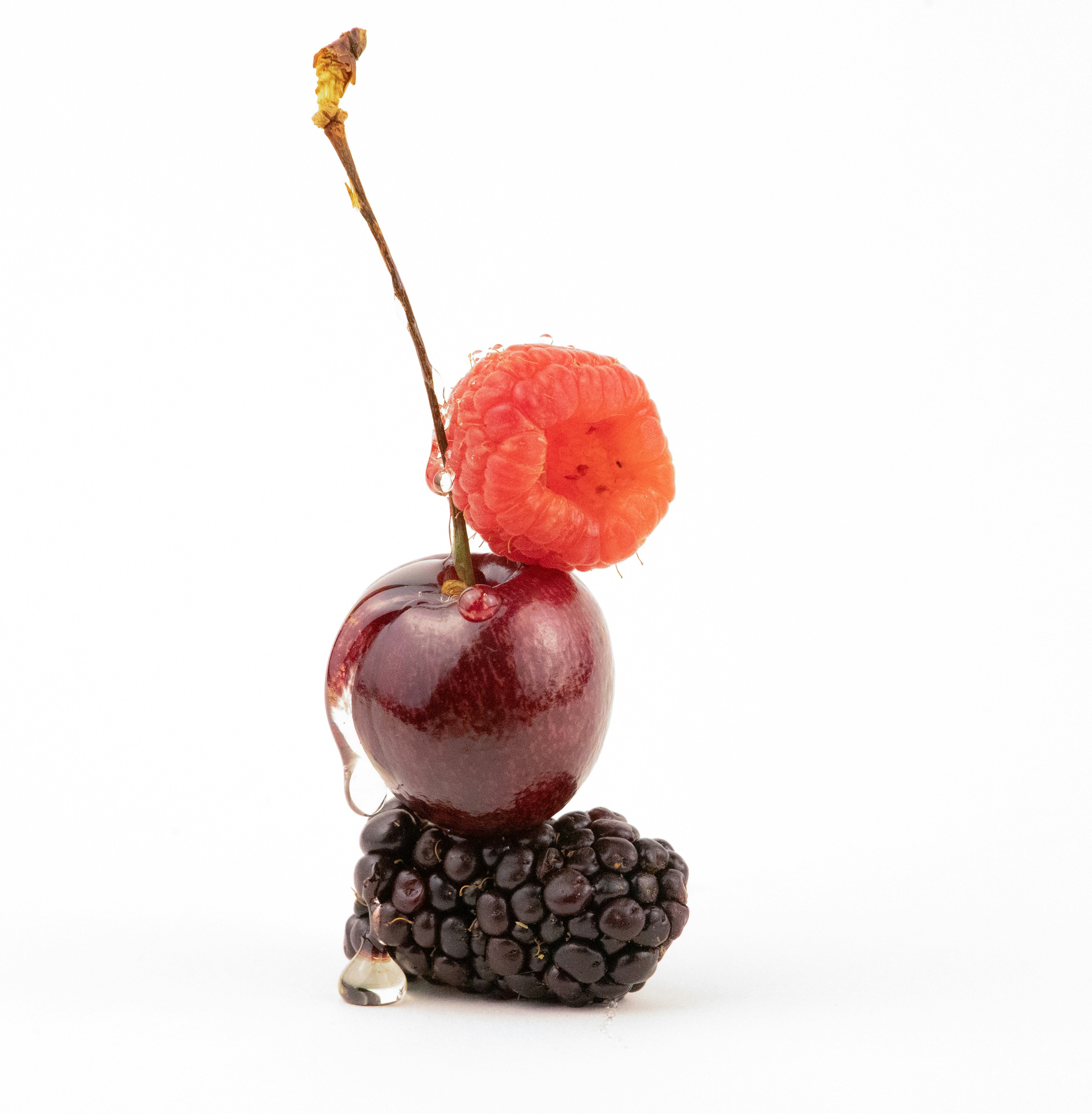 Einen Stapel Kirsche, Himbeere und Brombeere mit Wassertropfen.