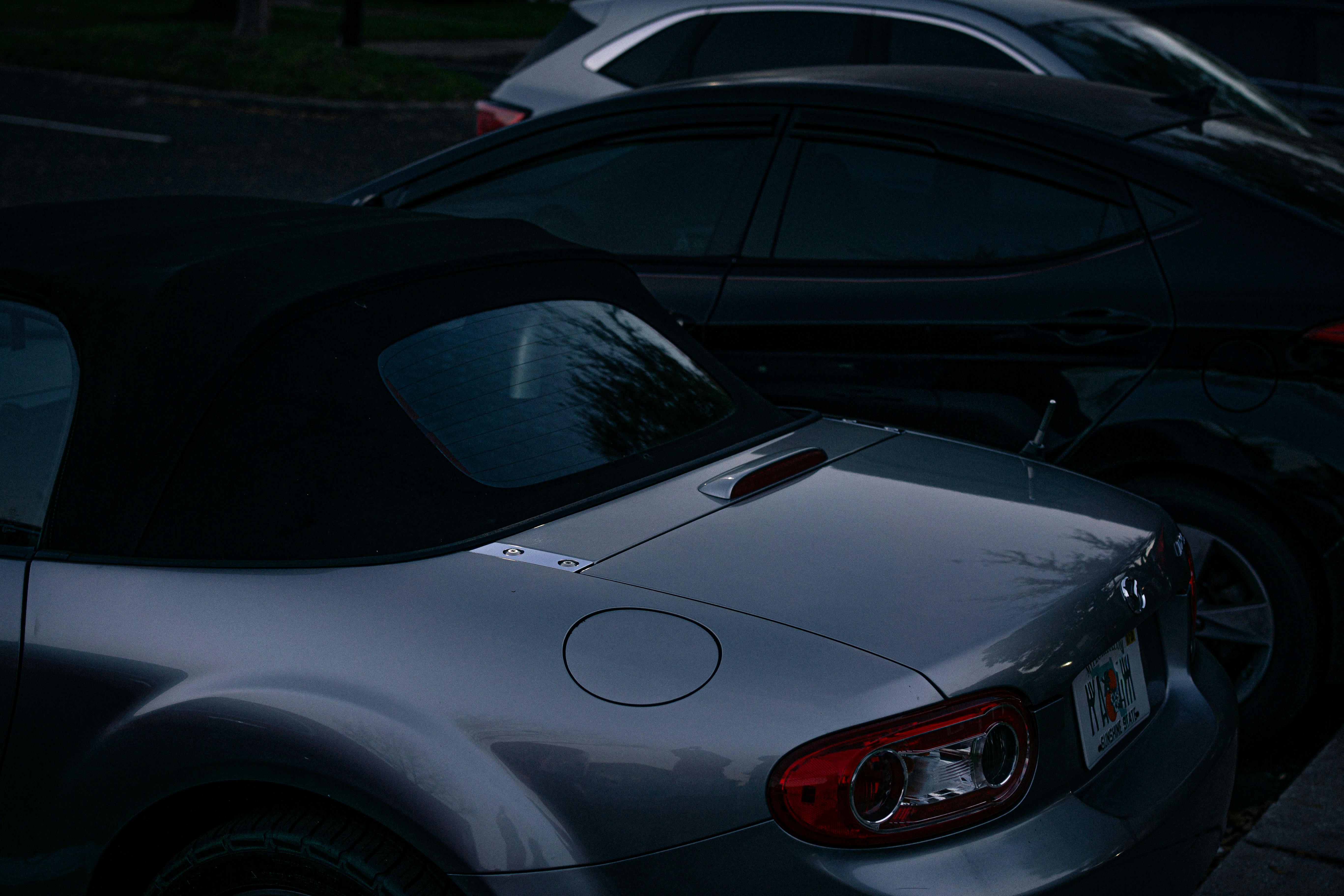 Two cars parked closely together at night.