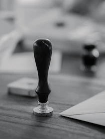 A wooden stamp sits on a wooden desk