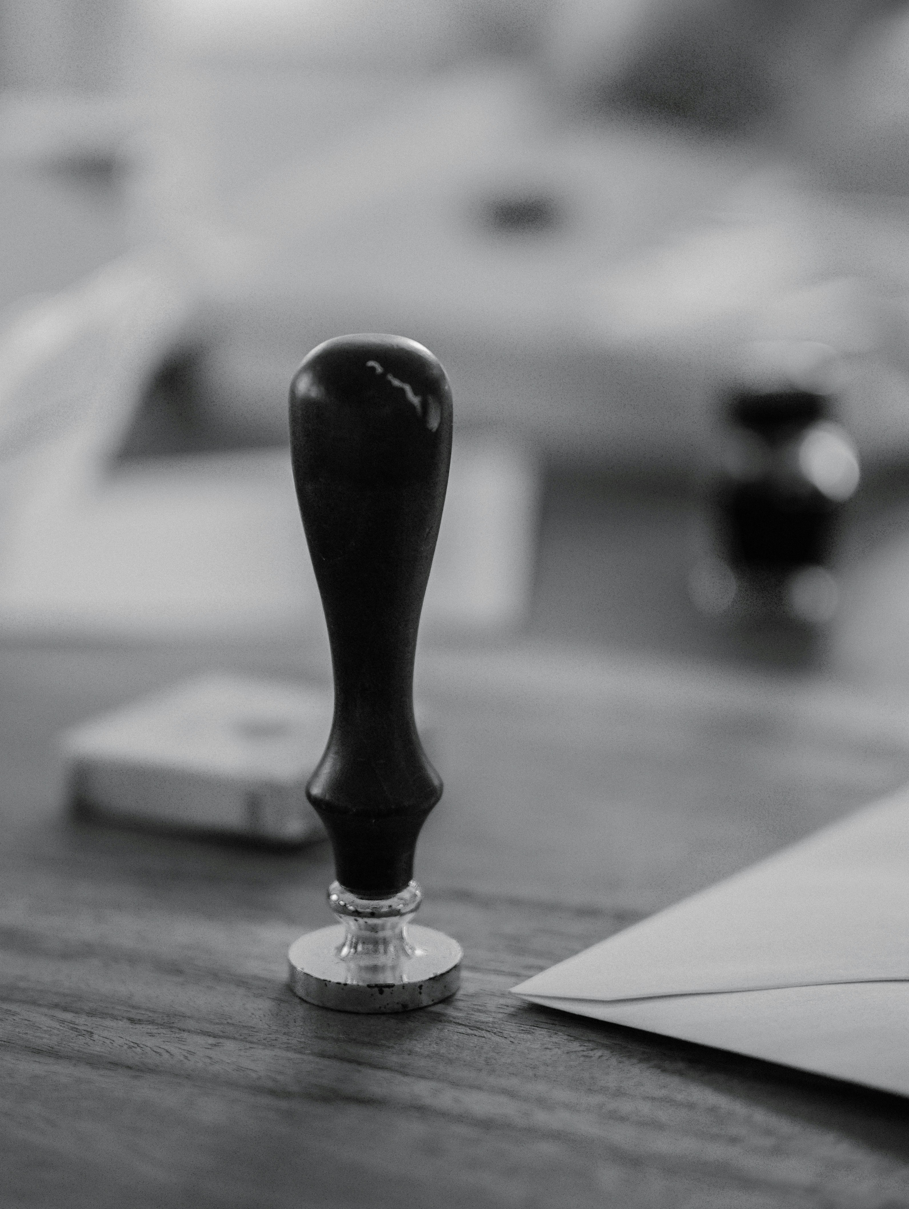 A wooden stamp sits on a wooden desk