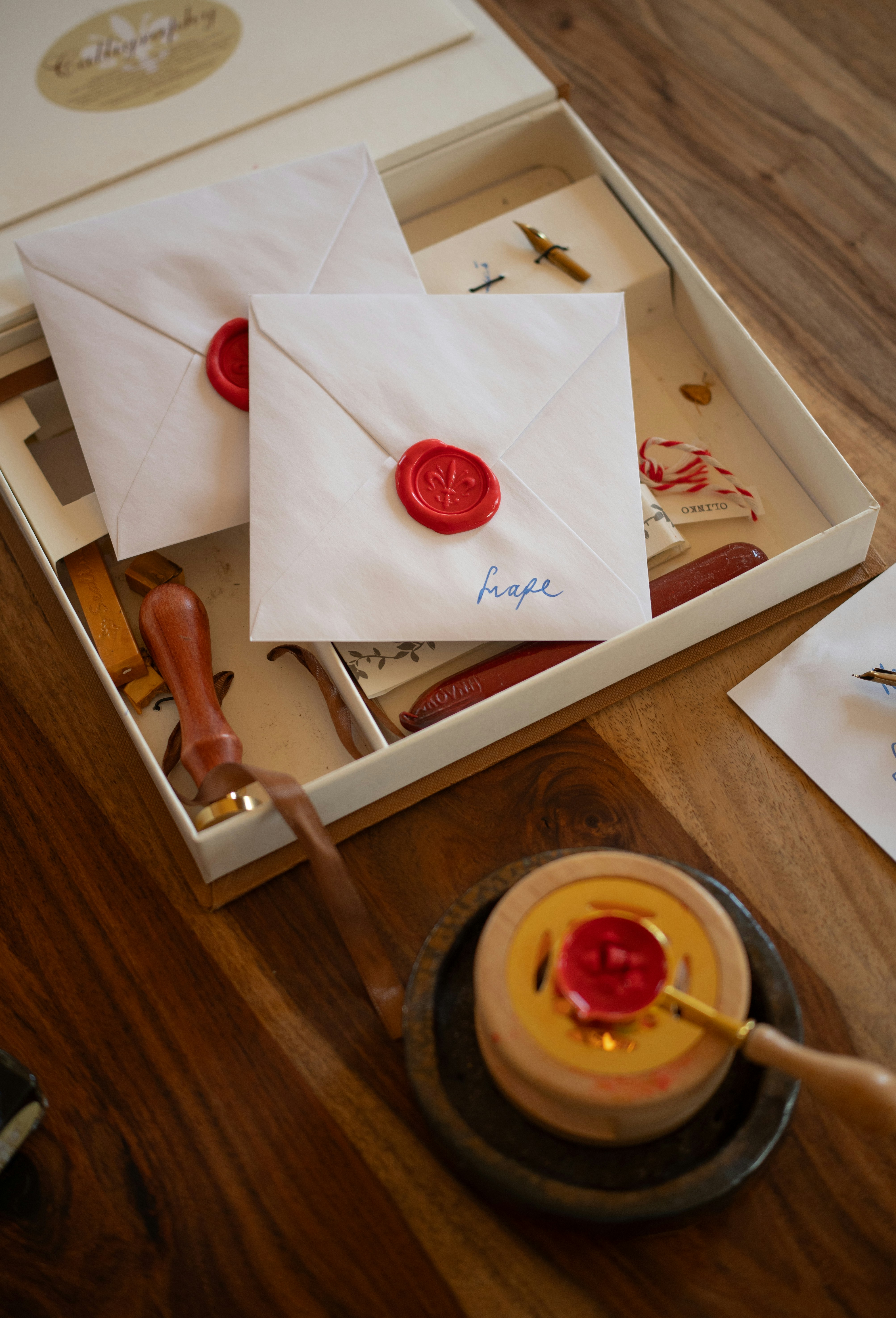 Sealed envelopes and calligraphy supplies on wooden table
