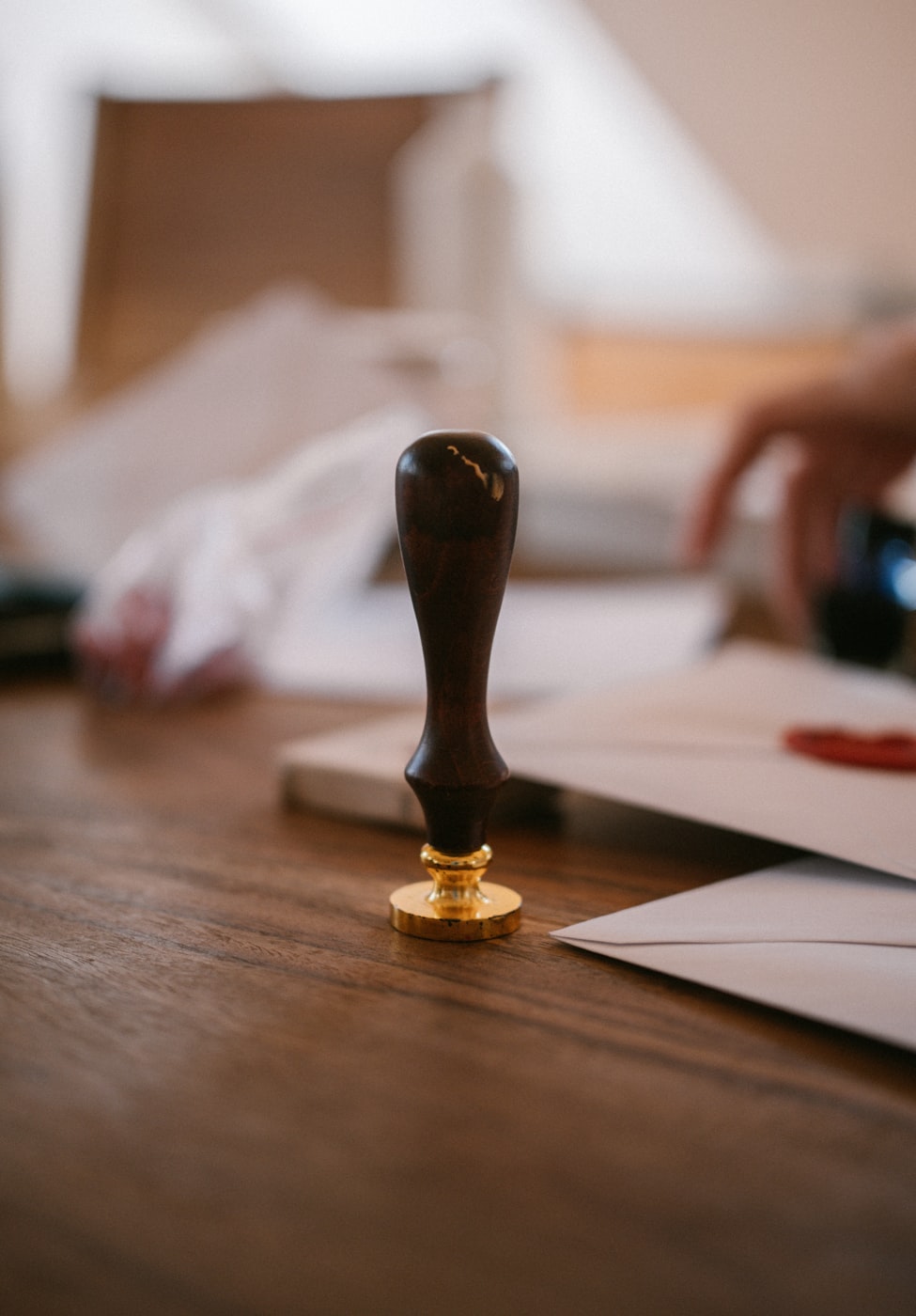 A wooden wax seal stamp resting on a worn wooden table