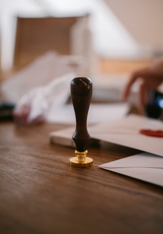 A wooden wax seal stamp resting on a worn wooden table
