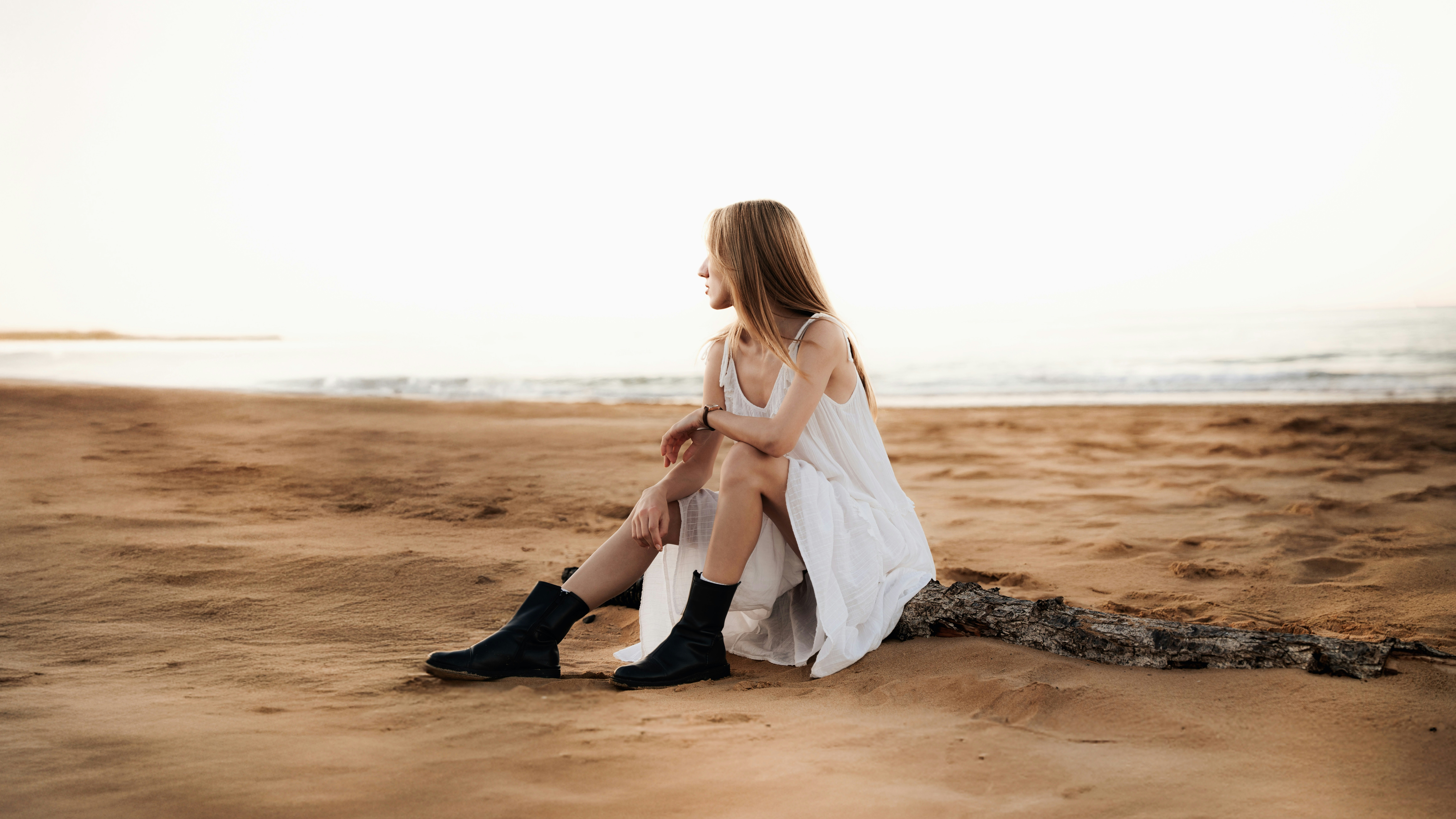 Woman in white dress sitting on a sandy beach. photo – Free Beach Image ...