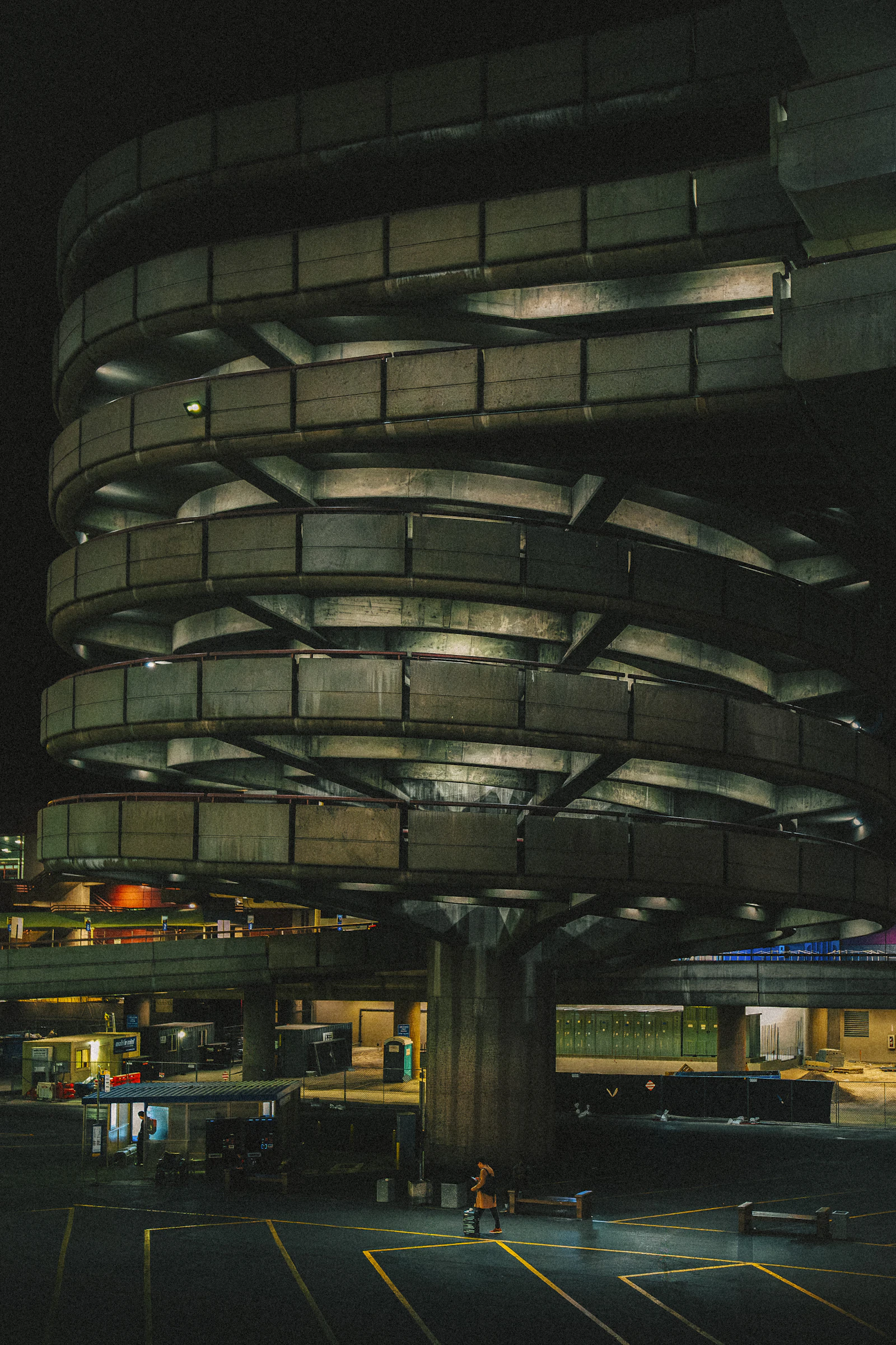 A spiral concrete car park glowing at night