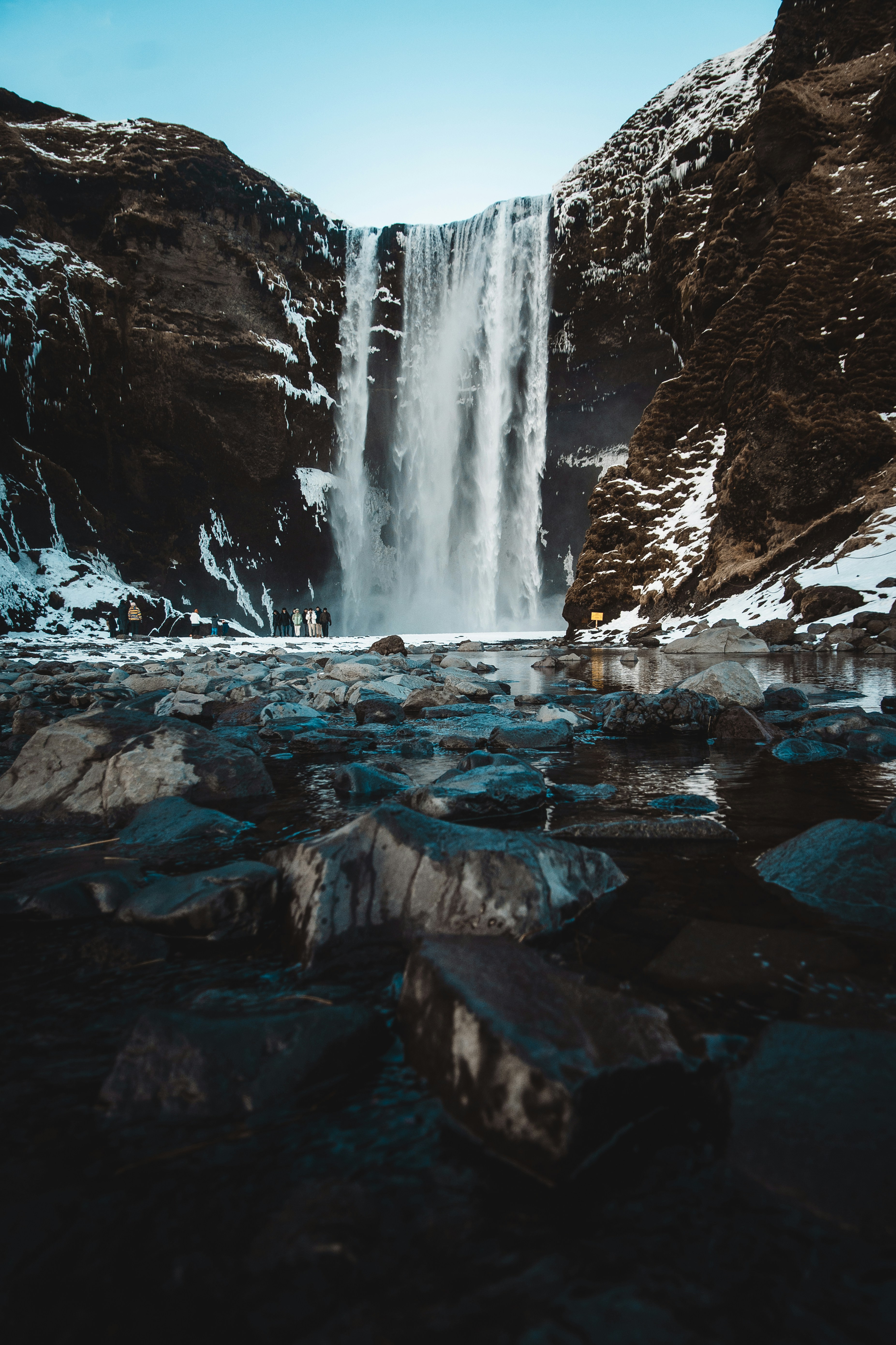 Majestosa cachoeira caindo por penhascos rochosos no inverno