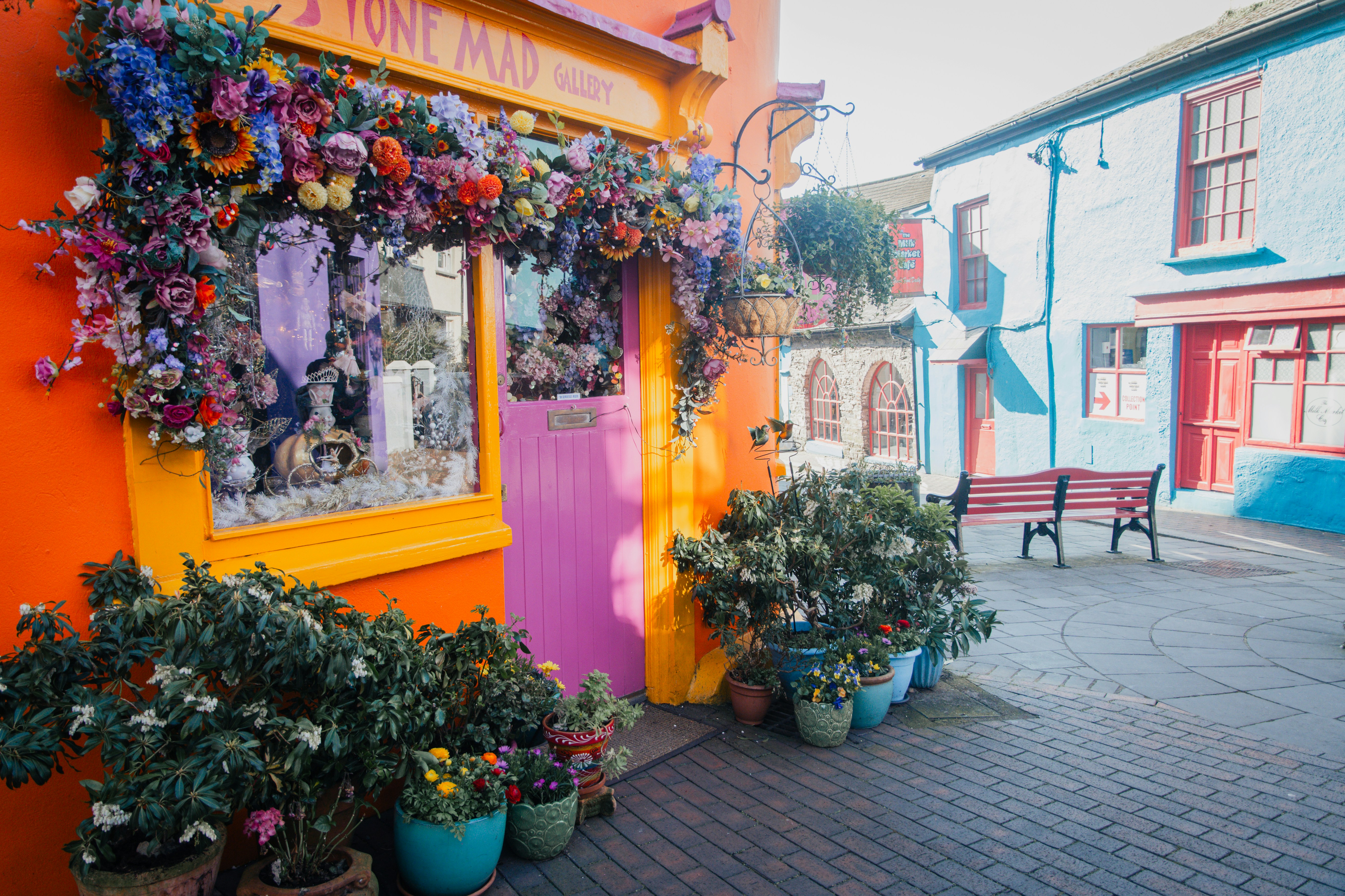 Colorful building adorned with abundant flowers and plants.