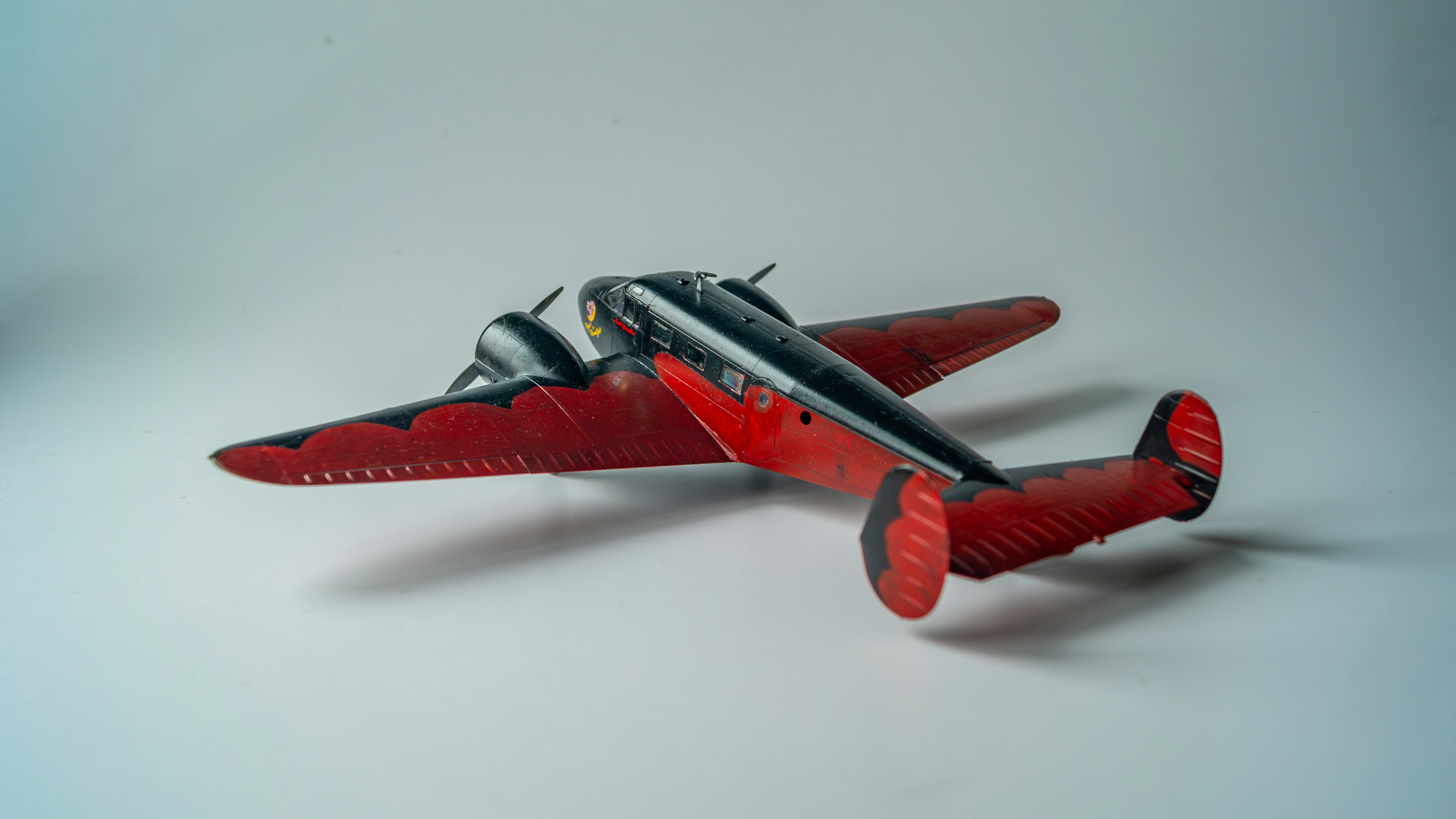 A red and black twin-engine airplane model.