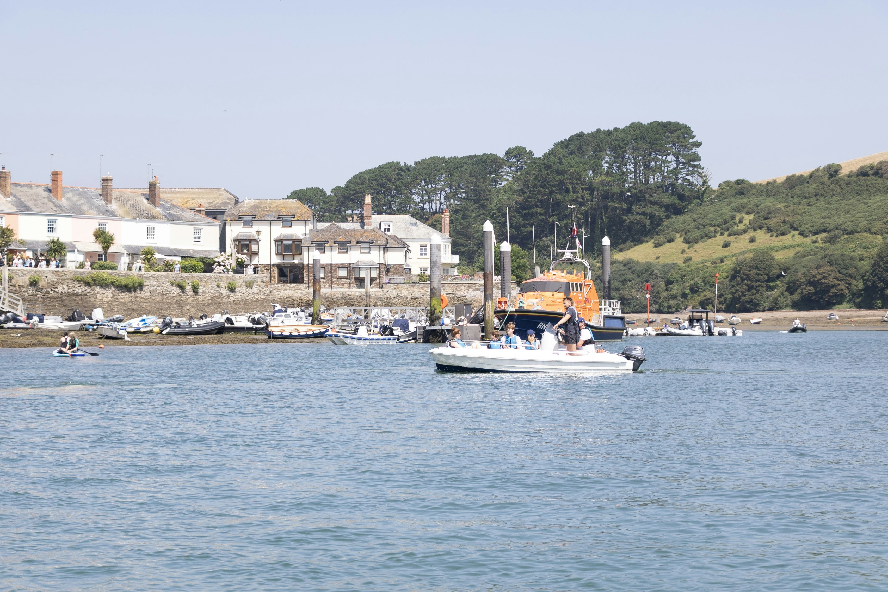 Boote auf dem Wasser mit Gebäuden und Hügeln im Hintergrund