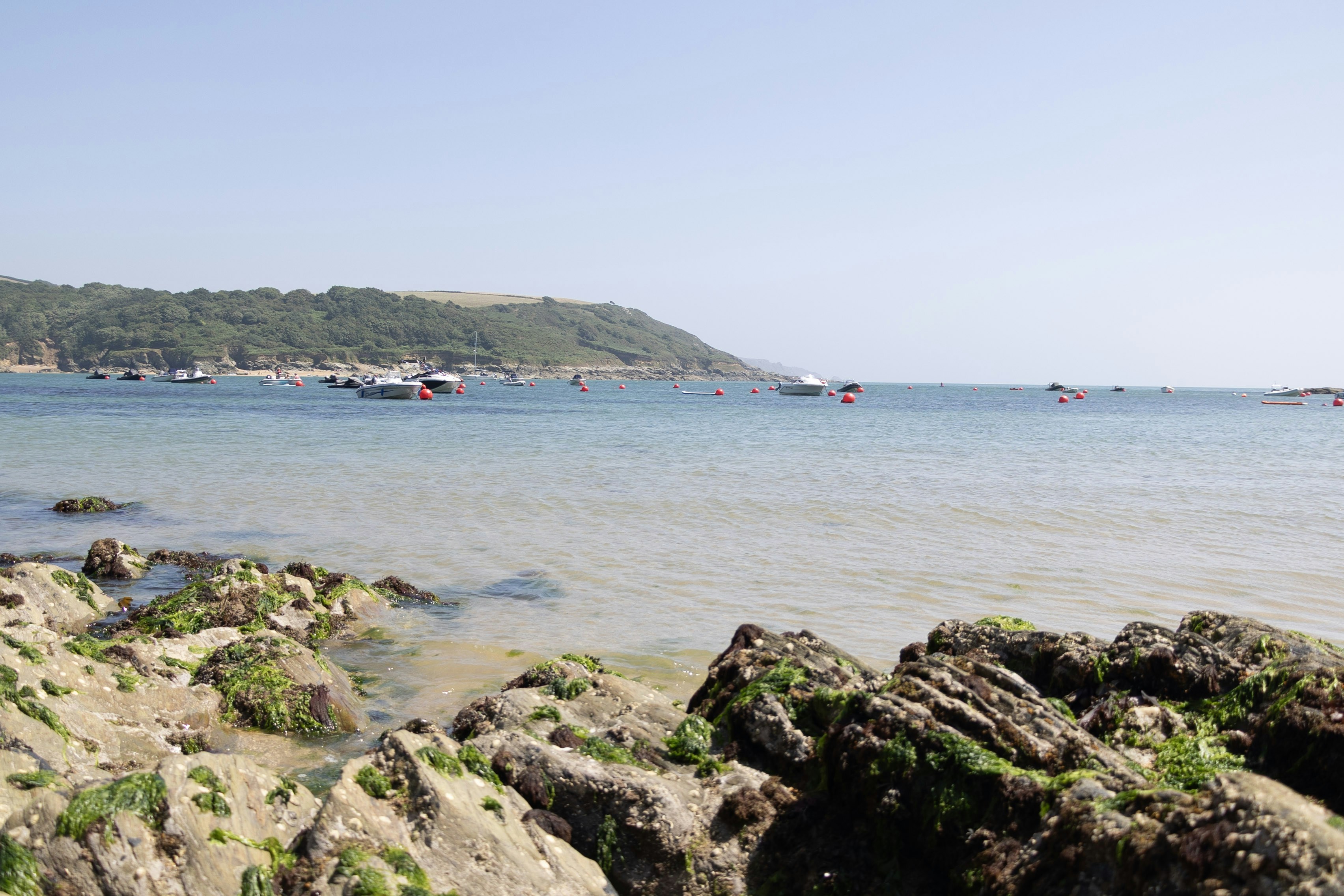 Boote auf dem Wasser in der Nähe einer felsigen Küste.